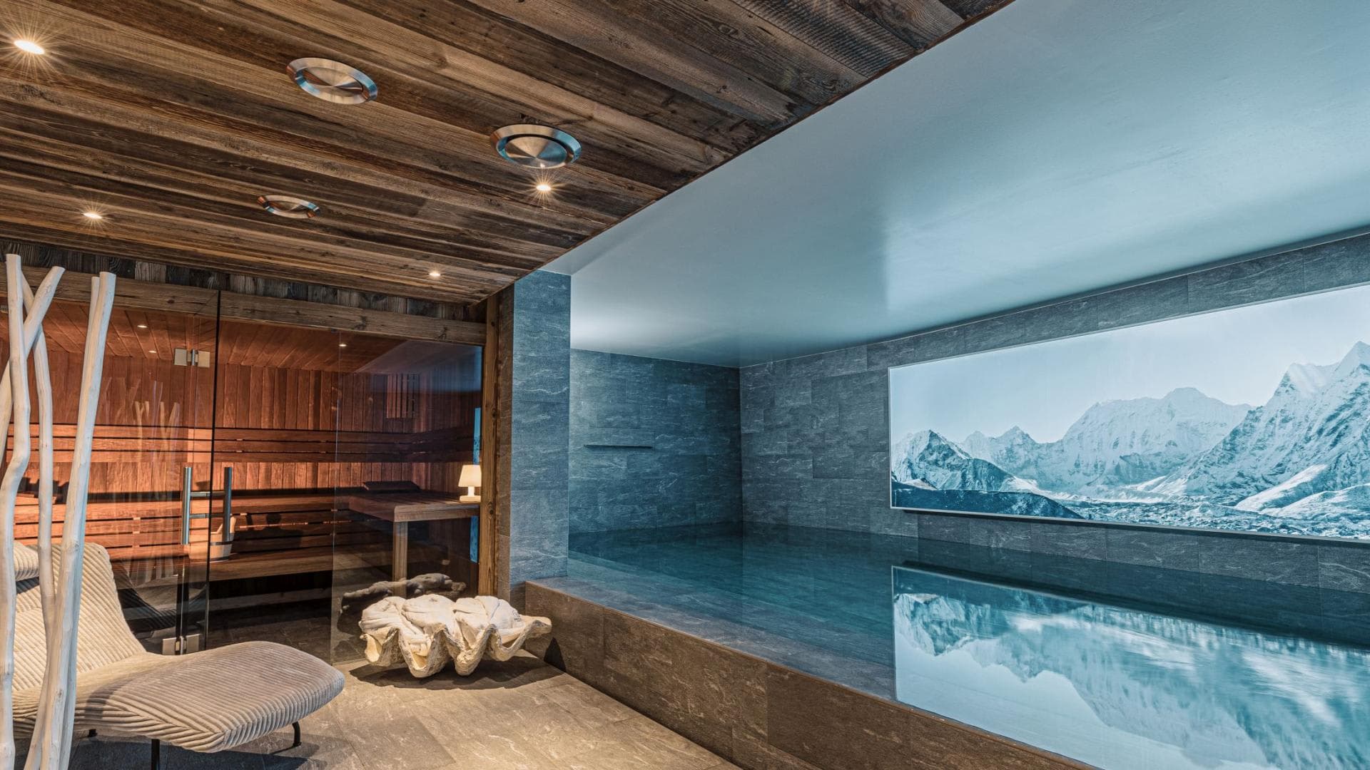 Indoor plunge pool and wood-paneled sauna with mountain landscape view