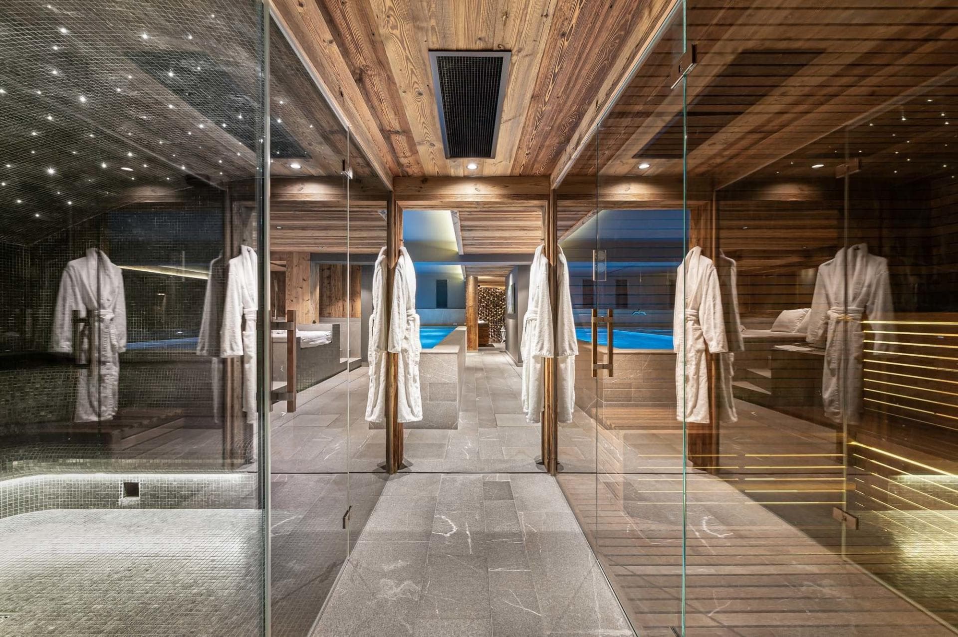 Spa area with glass-enclosed steam room, sauna, and indoor pool access