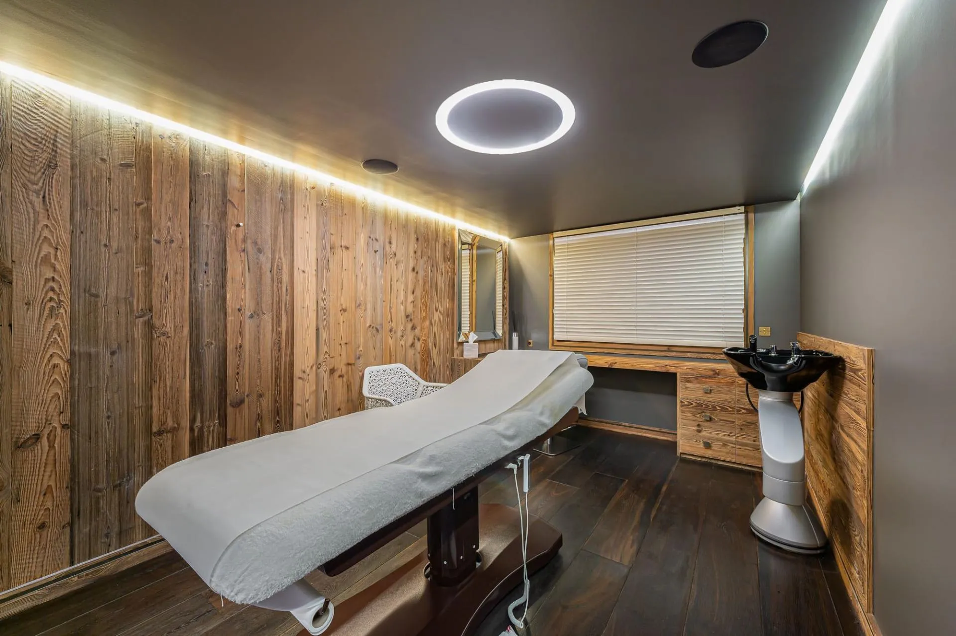 Treatment room with massage table and hair-washing basin