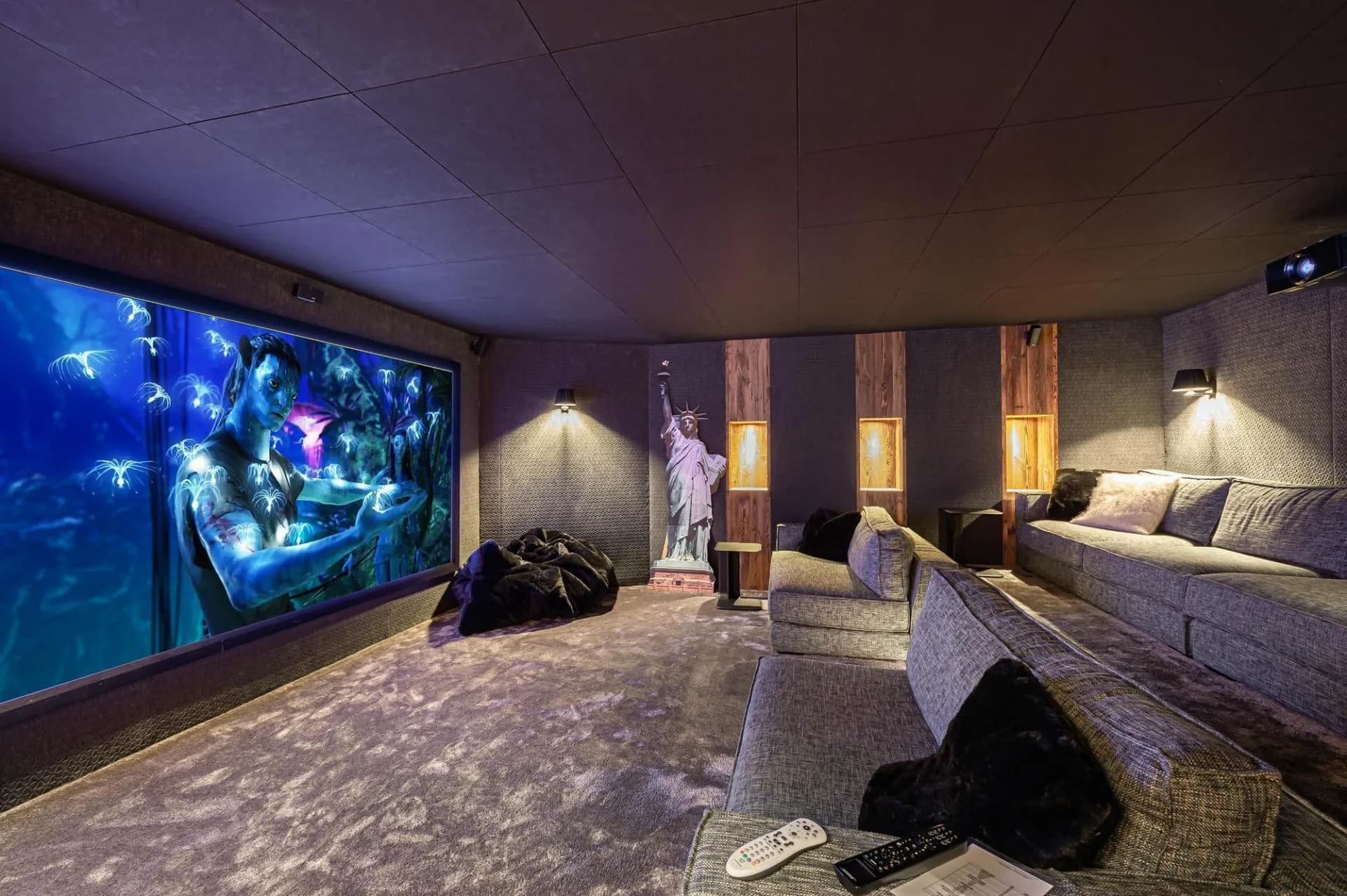 Private cinema with projection screen and sofa seating