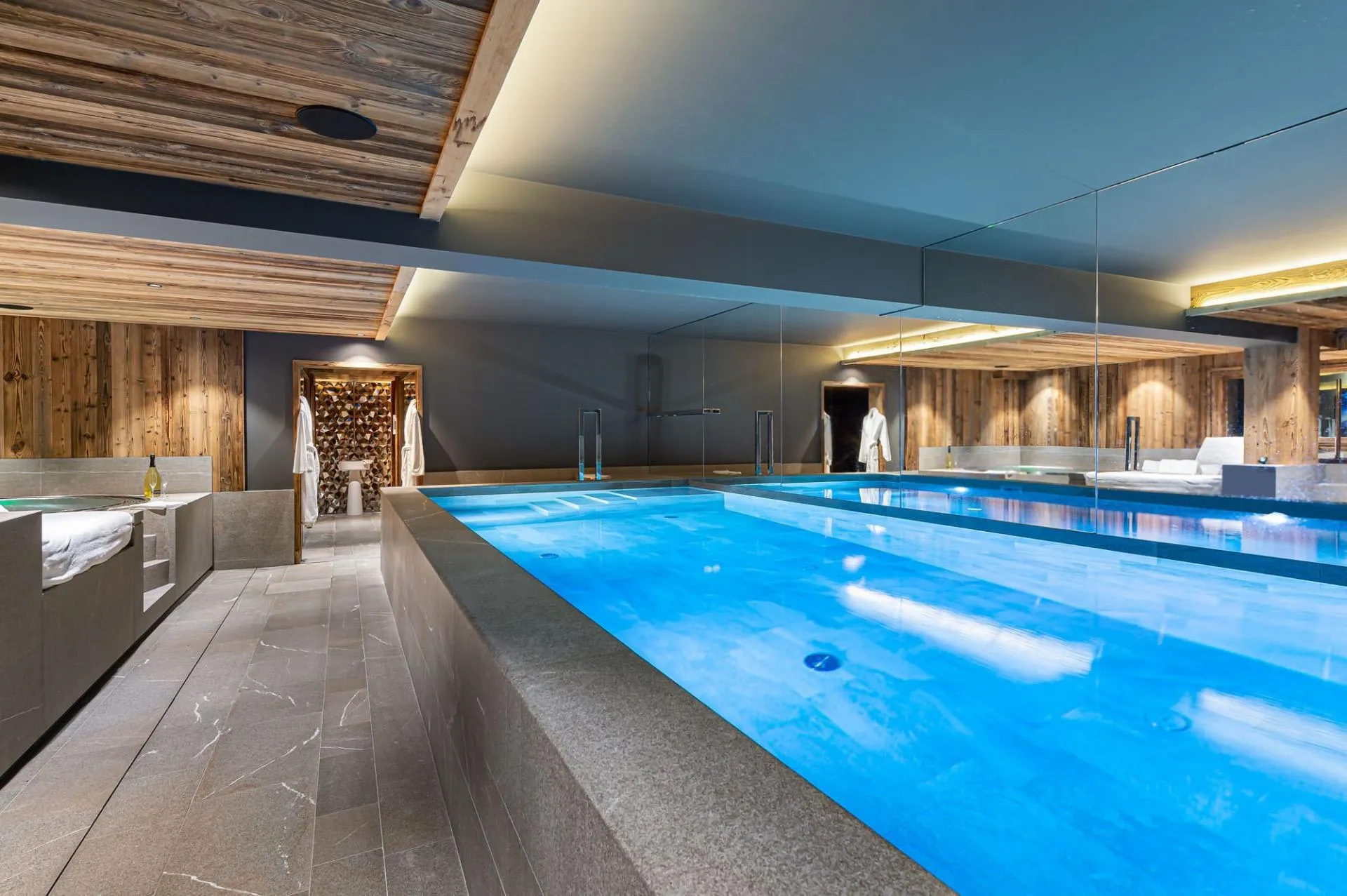 Indoor swimming pool with timber walls and illuminated ceiling