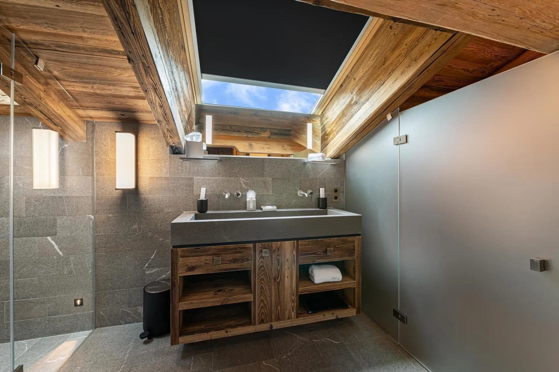 Bathroom with double basins and walk-in shower beneath skylight