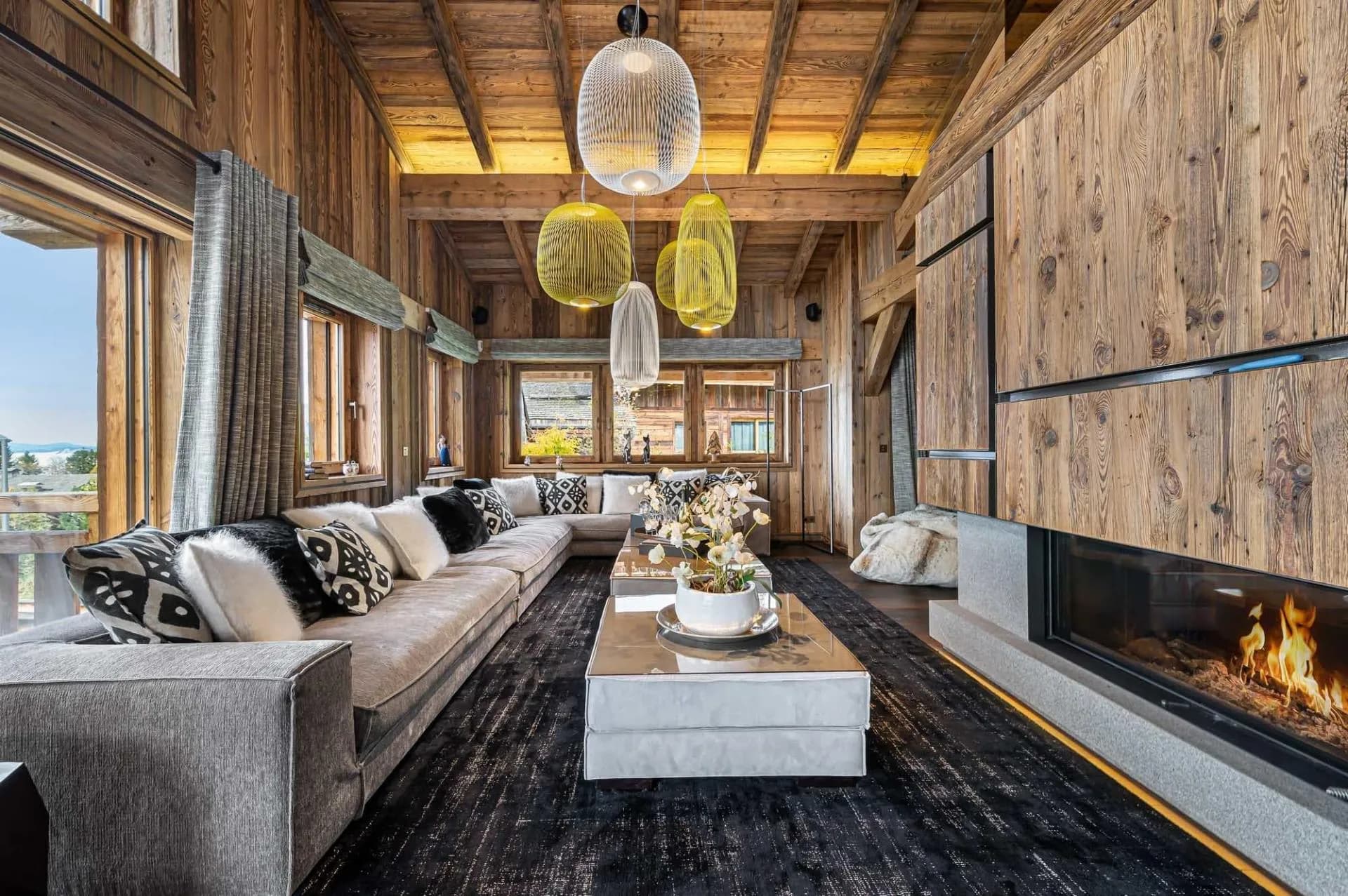 Sofas beside the central fireplace and mountain-facing windows