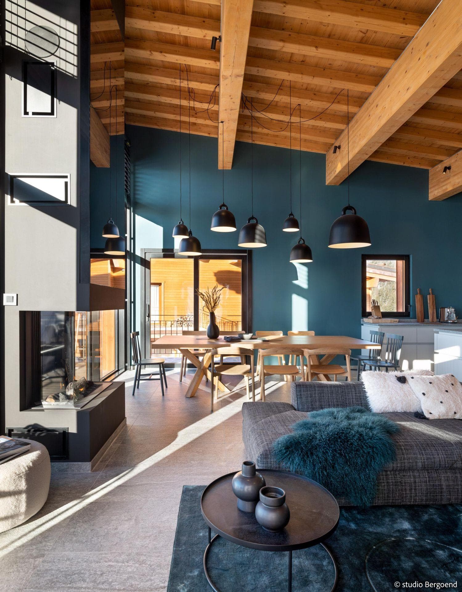 Open-concept living area with 3-sided glass fireplace and 8-seat dining table