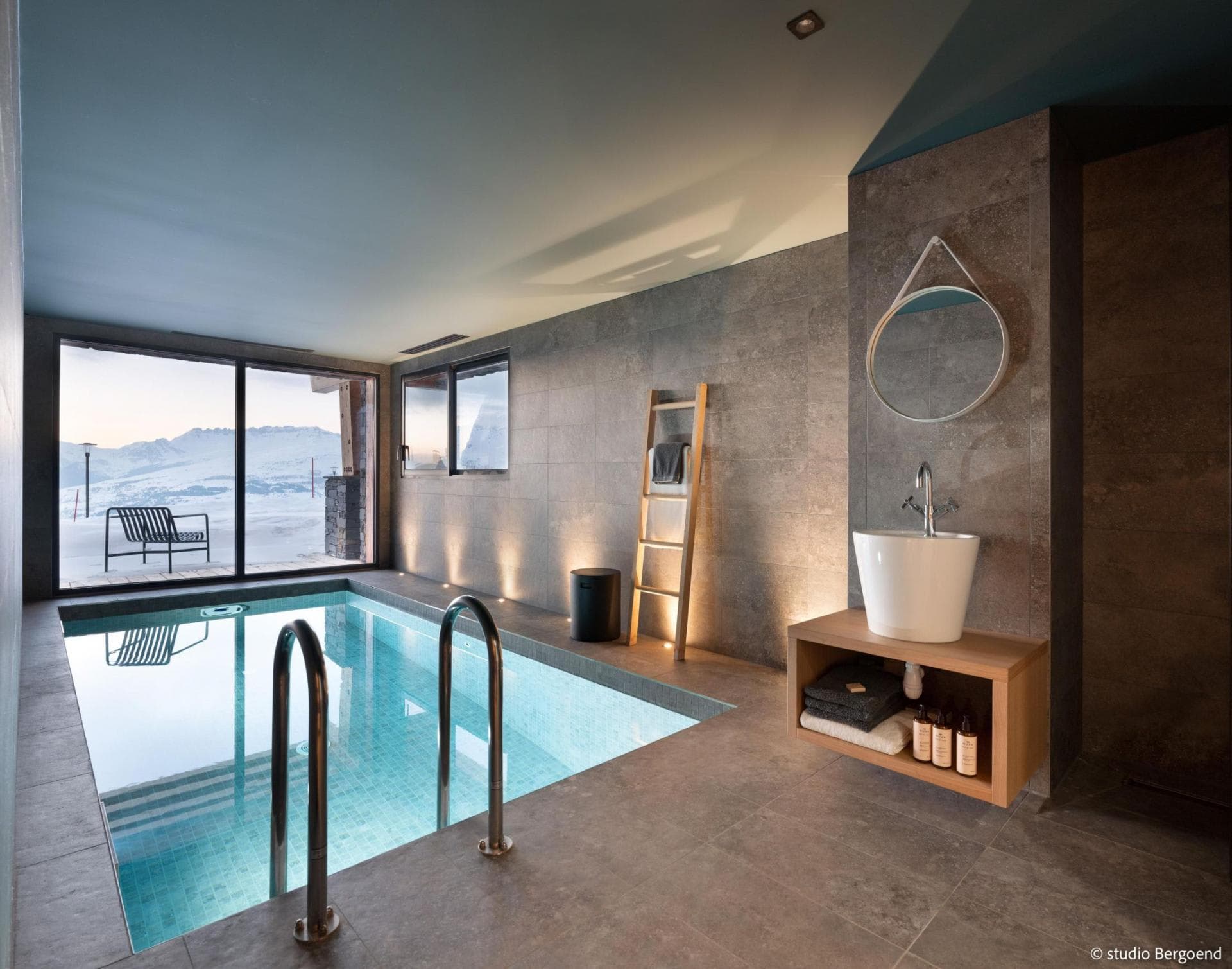 Indoor pool with alpine views and adjacent vanity area