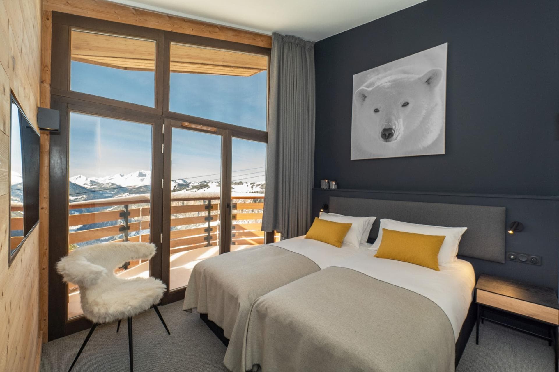 Bedroom with twin beds, private balcony, and alpine mountain views