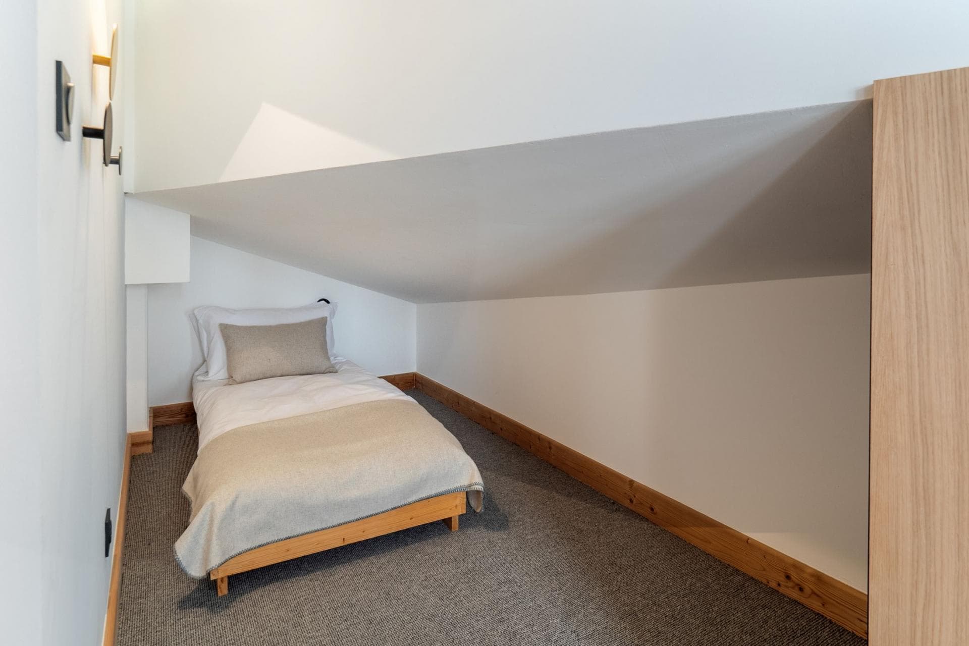 Sleeping nook with single bed and sloped ceiling