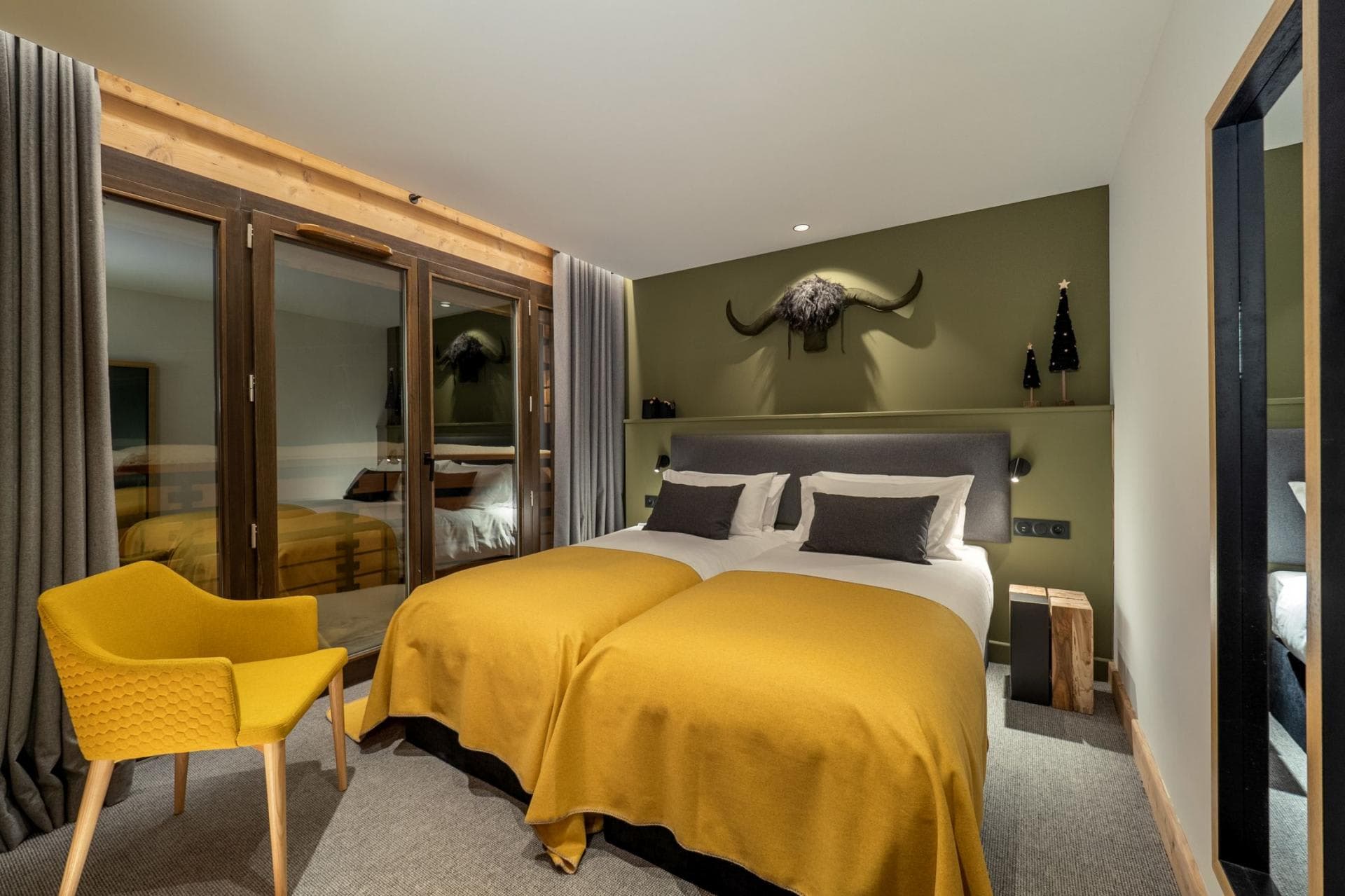 Guest bedroom with twin beds and floor-to-ceiling glass patio doors