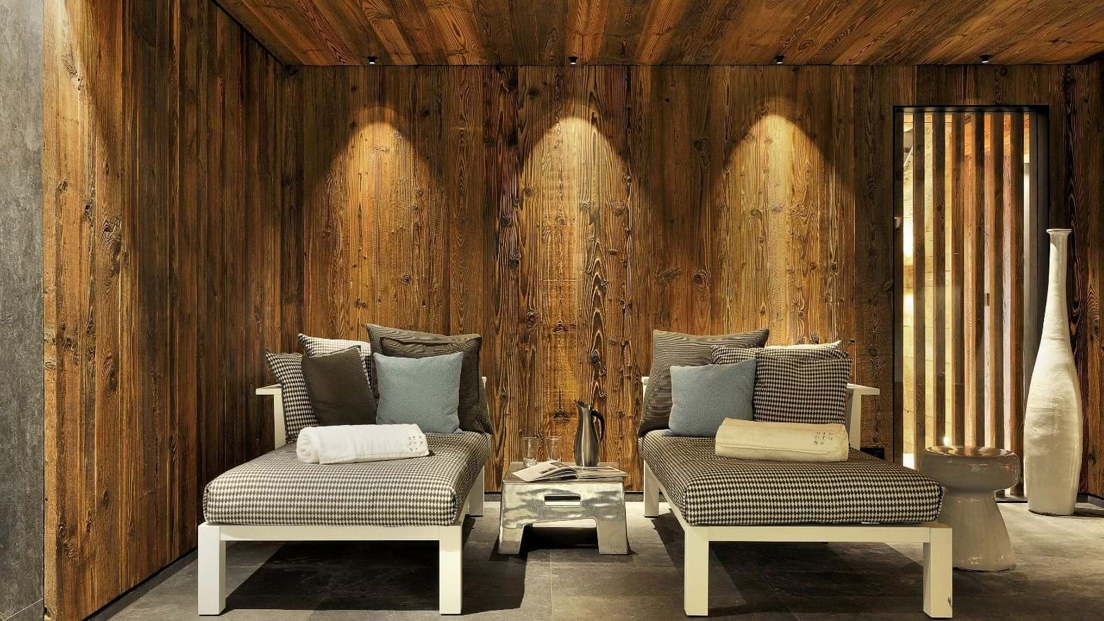 Spa relaxation room with heated loungers and reclaimed wood paneling