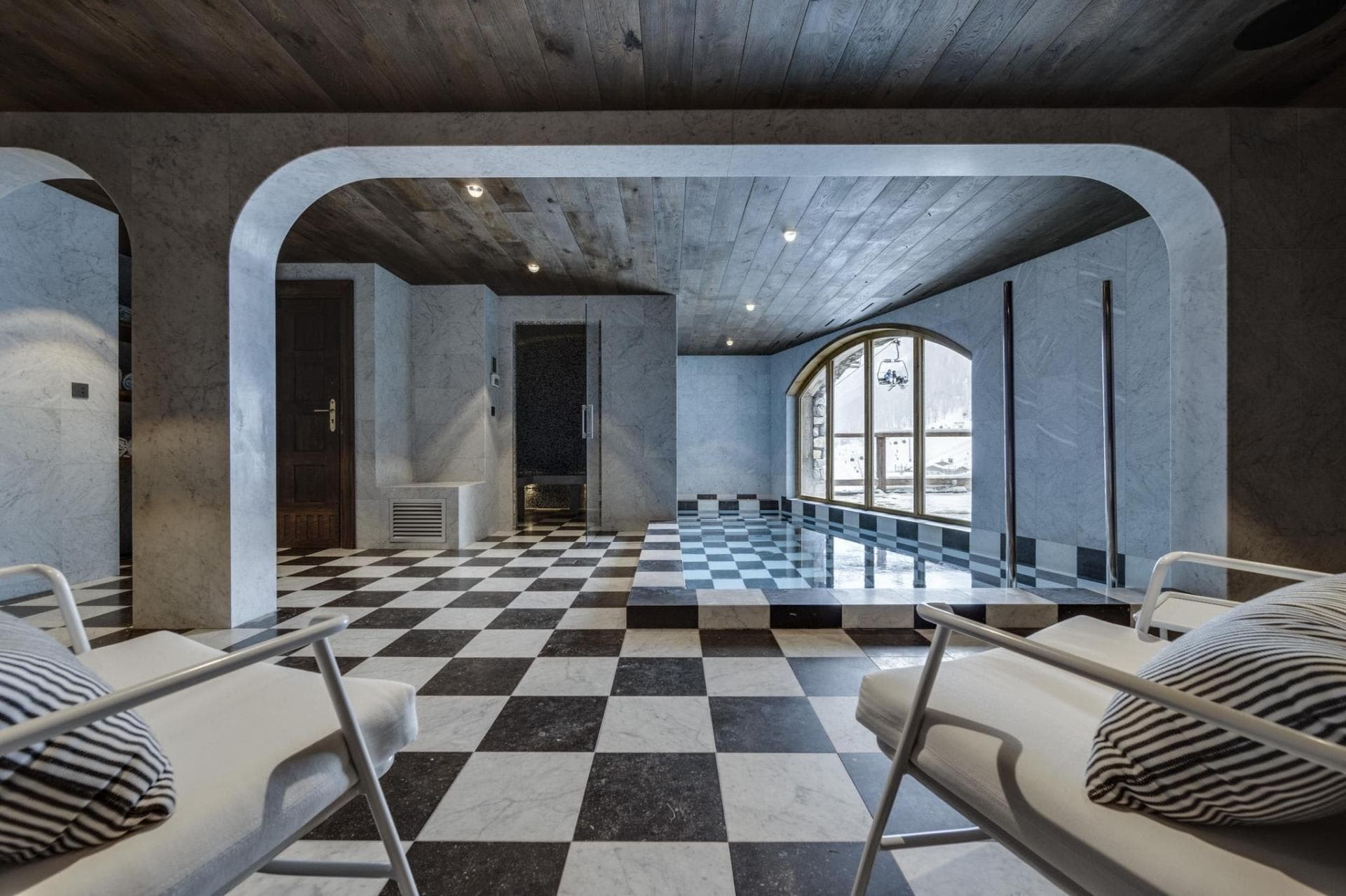 Indoor plunge pool and steam room with checkered marble flooring