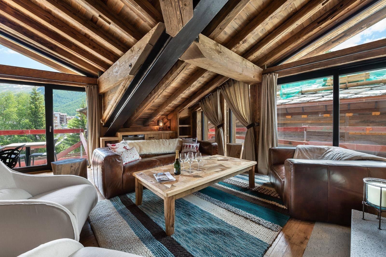 Top-floor living area with vaulted timber beams and private balcony access