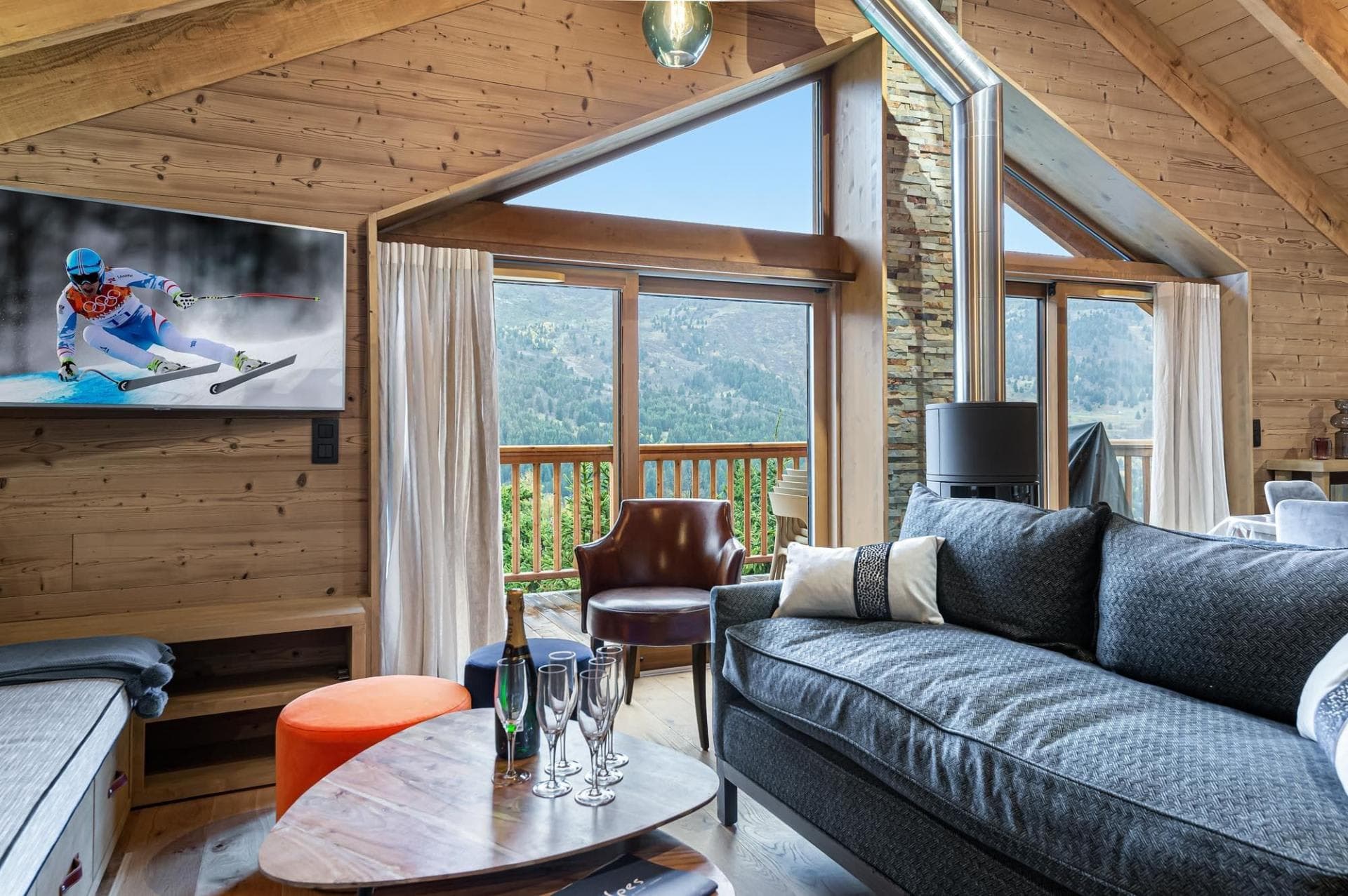 Living room with wood stove and mountain views via floor-to-ceiling windows