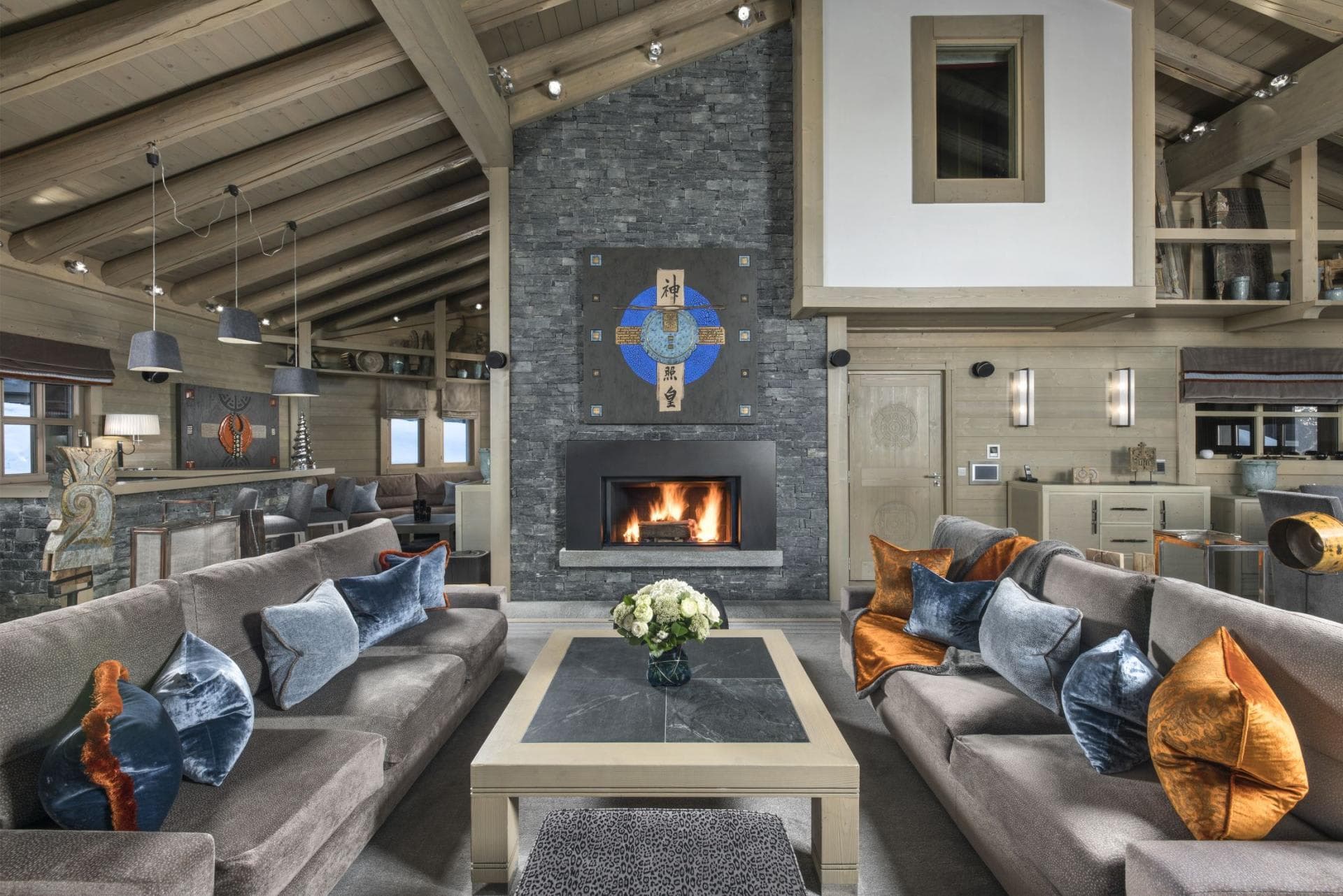Living area with wood-burning fireplace and vaulted timber ceilings