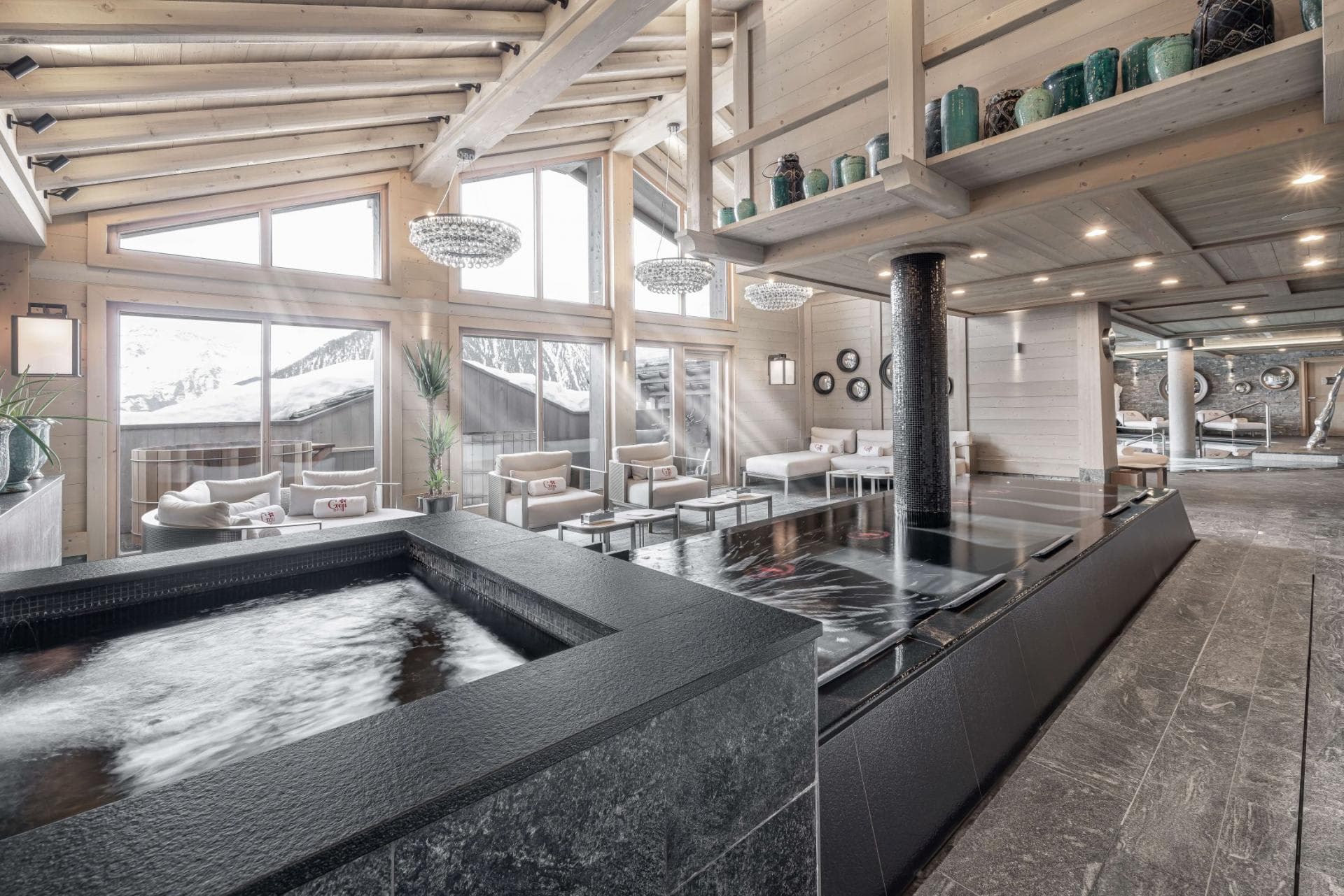 Indoor spa area with heated lap pool and mountain-facing lounge seating
