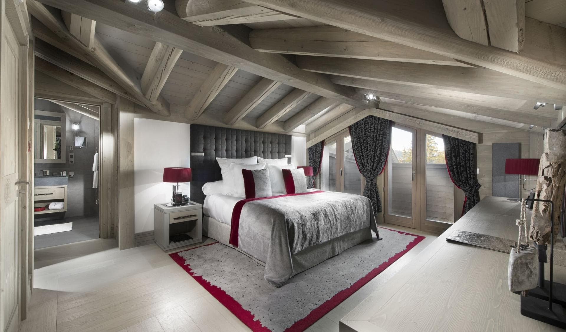 Primary bedroom with ensuite bathroom, king bed, and vaulted timber ceilings