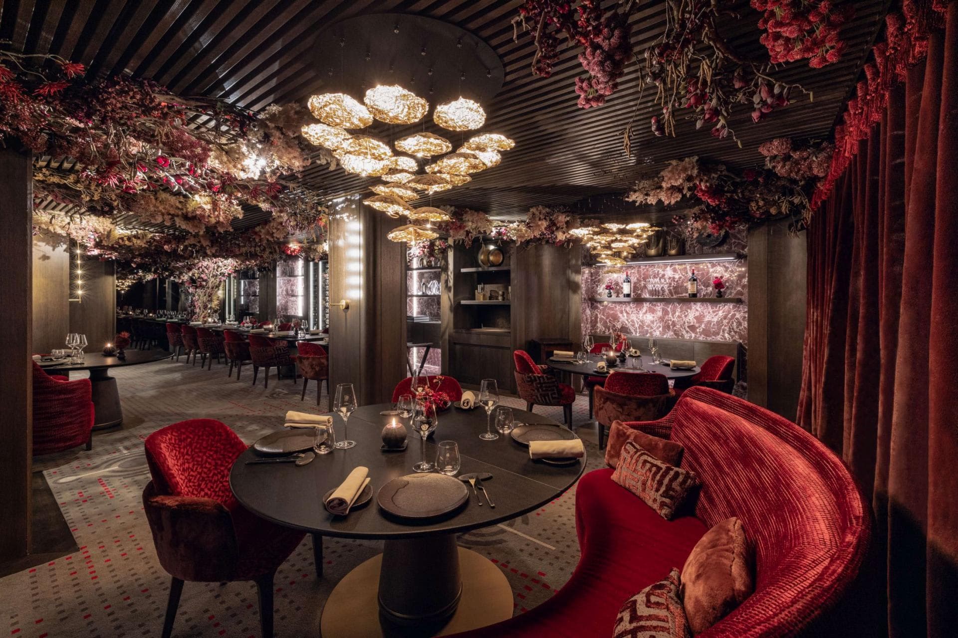 Formal dining room with banquette seating and floral ceiling installations