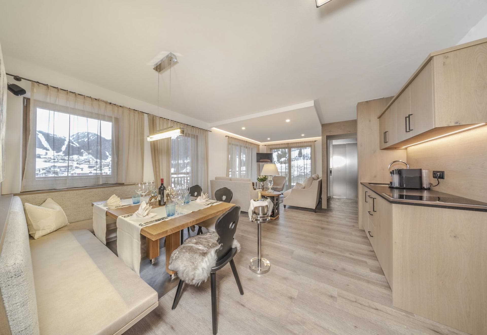 Open-plan living area with 6-seat dining table and ski slope views