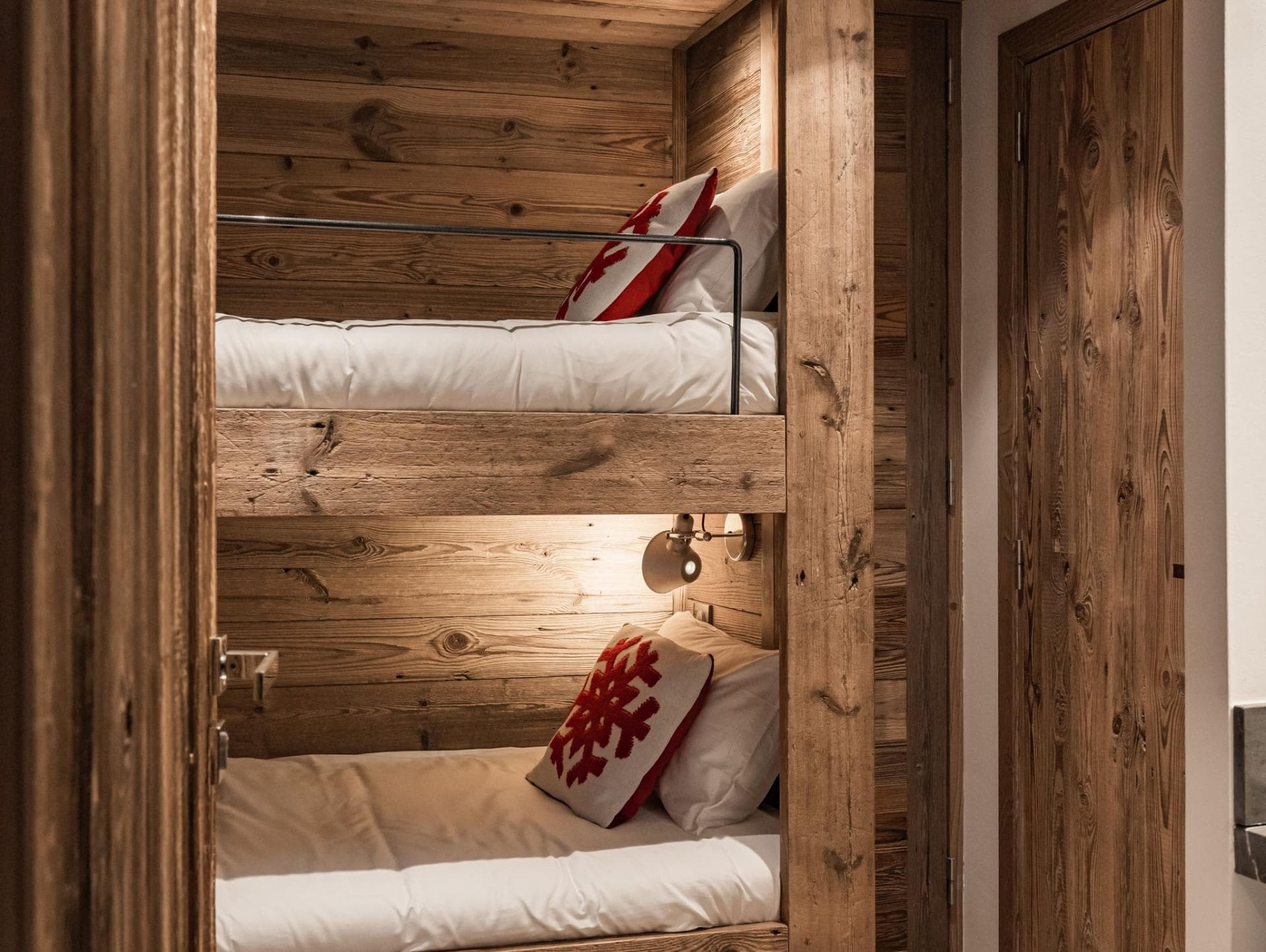 Bunk room with built-in reclaimed wood beds and individual reading lights