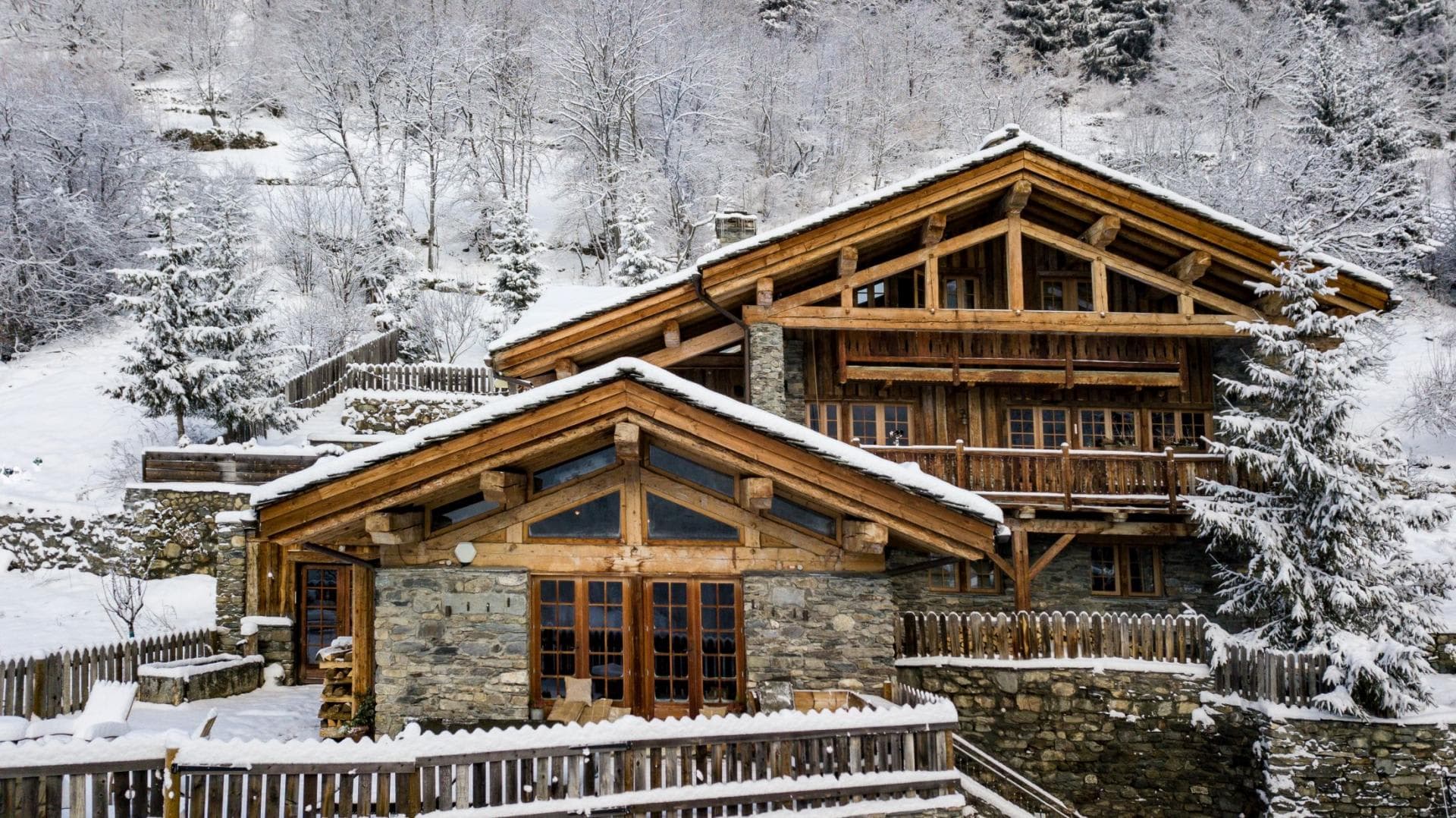 Ski-in chalet with stone facade and wraparound timber balconies