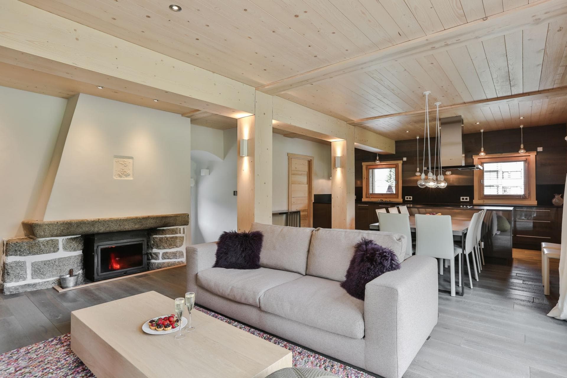 Open-plan living area with wood-burning fireplace and dining seating for 6