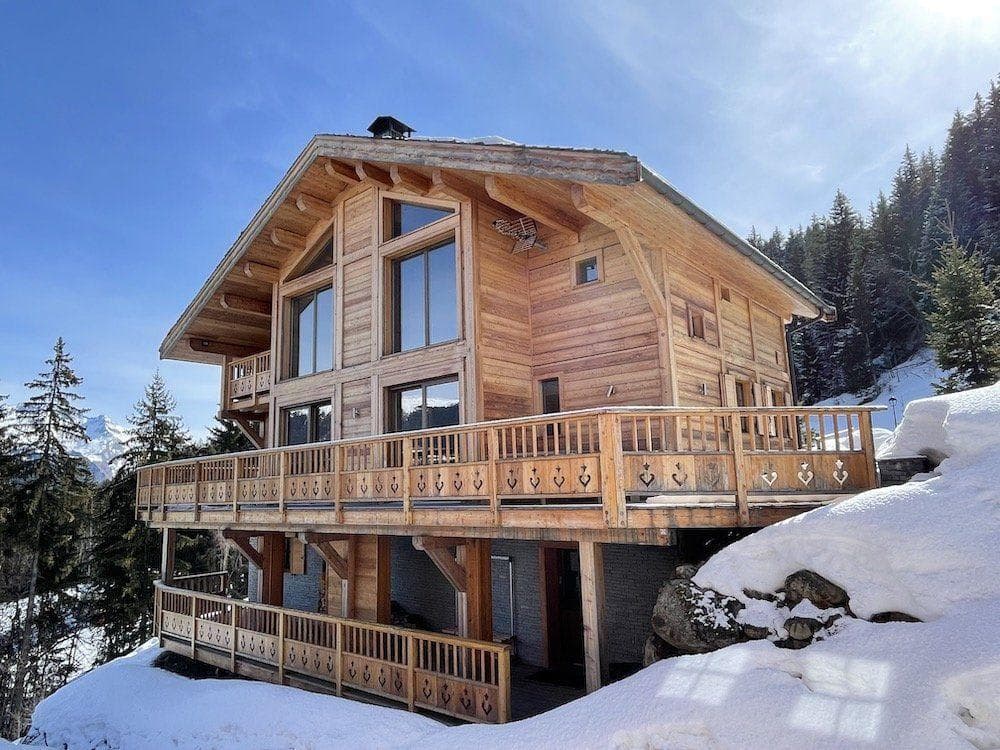 Ski-in chalet exterior featuring wrap-around deck and mountain views