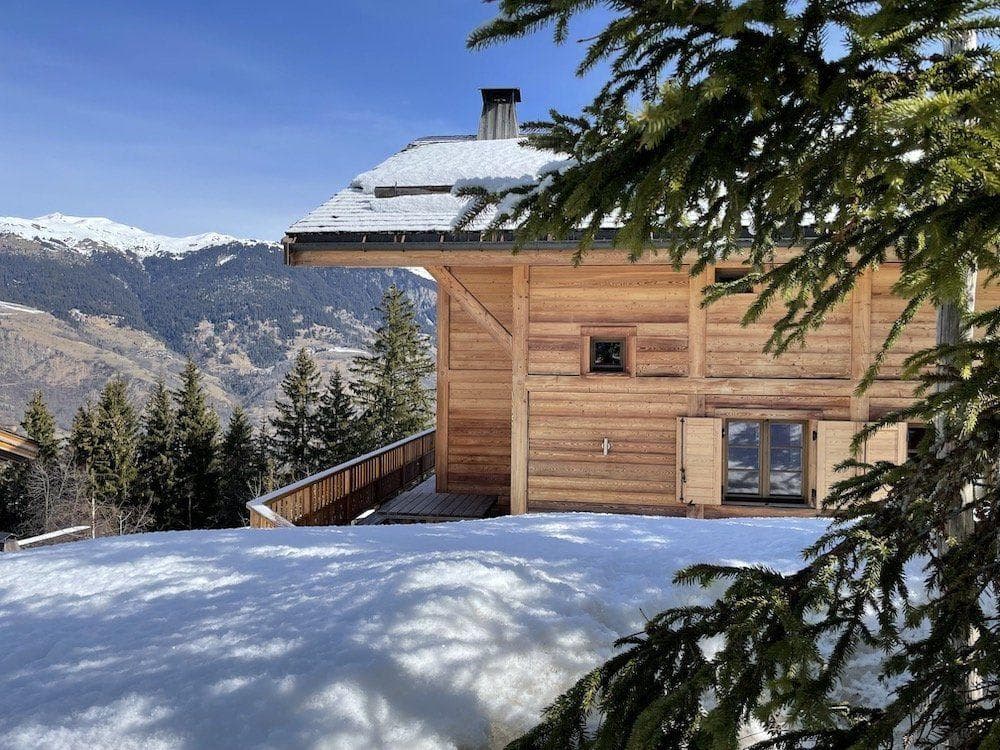 Timber chalet exterior with panoramic mountain views and wrap-around deck