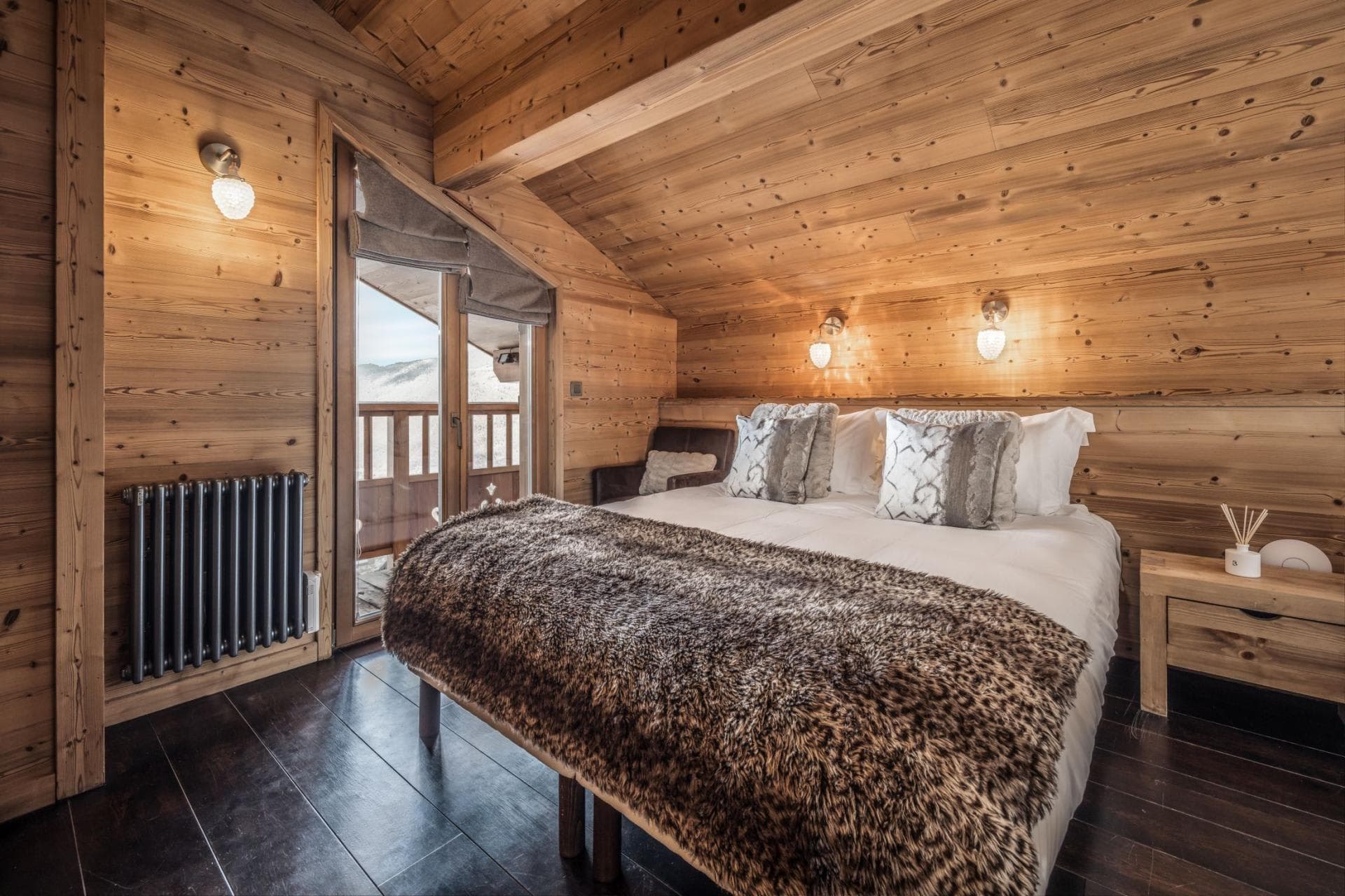 Wood-paneled bedroom with king bed and private balcony access