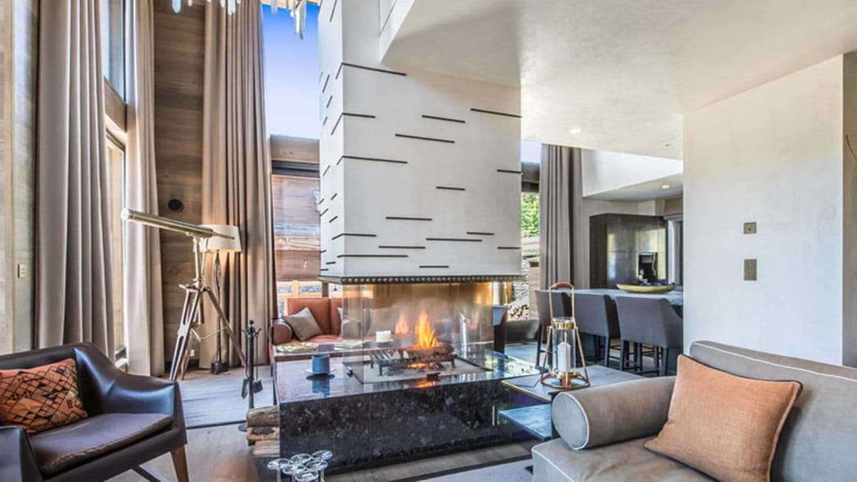 Living area with three-sided gas fireplace and floor-to-ceiling windows