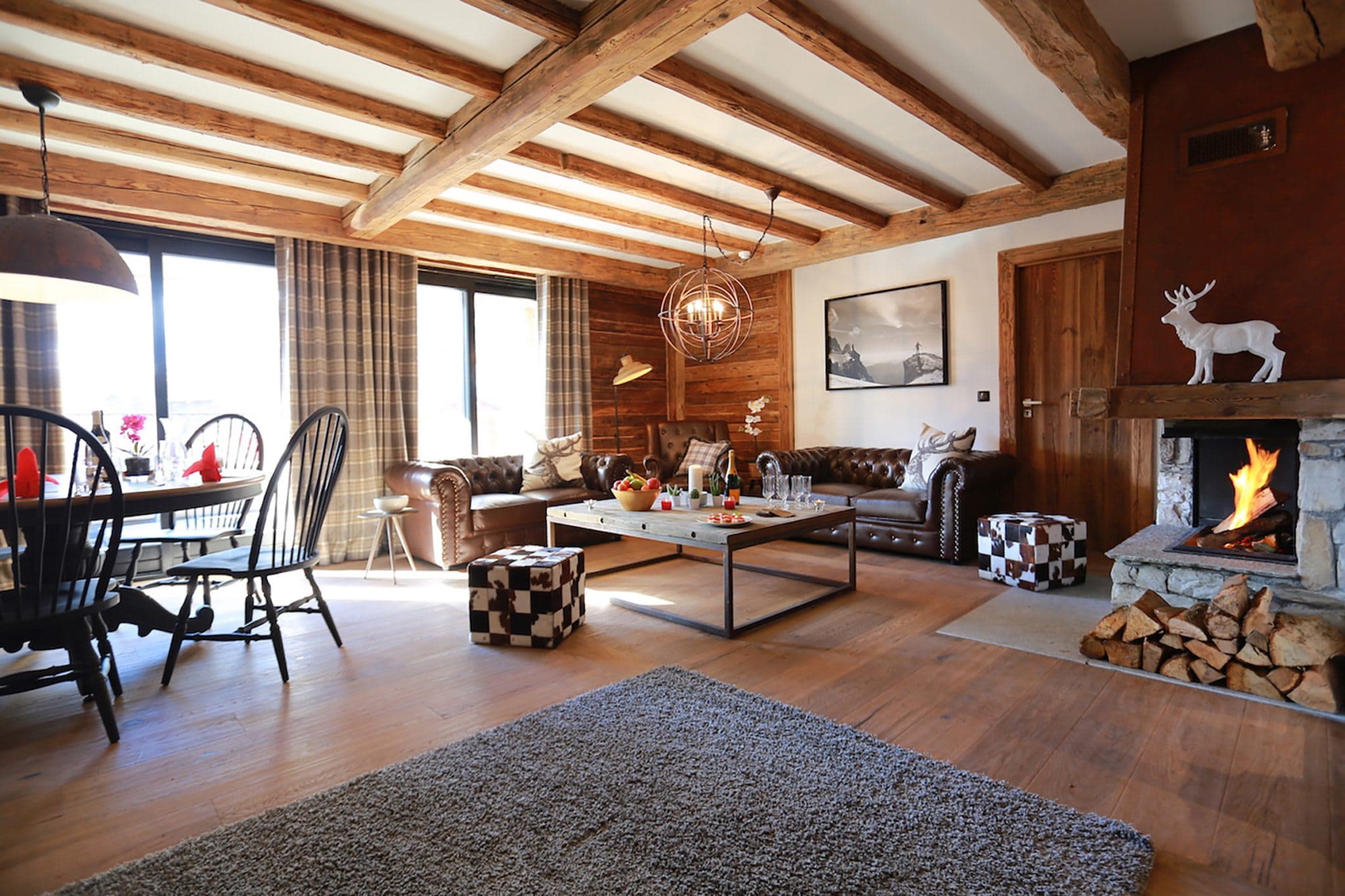 Open-plan living area with wood-burning fireplace and exposed timber beams