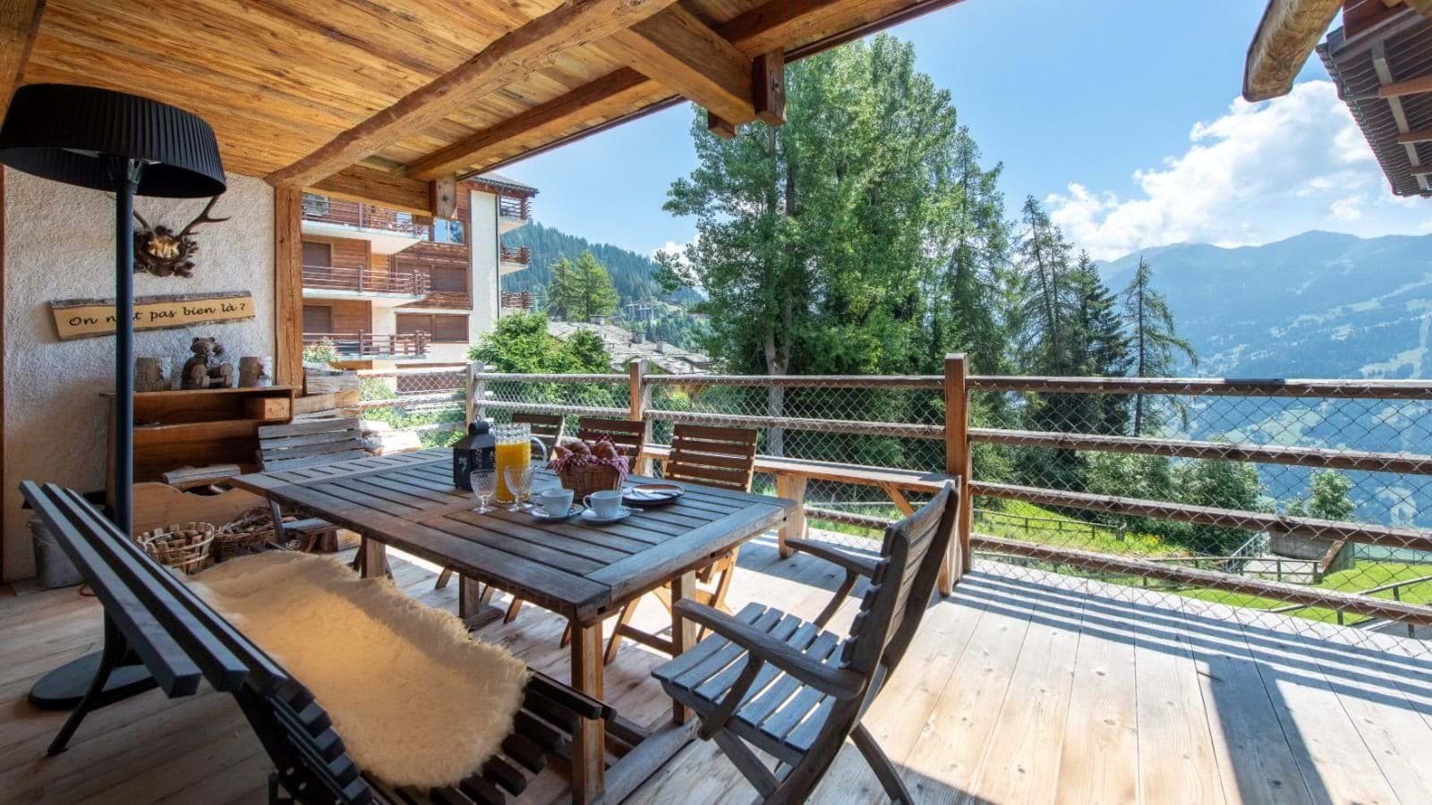 Covered wooden balcony with seating for 8 and mountain views