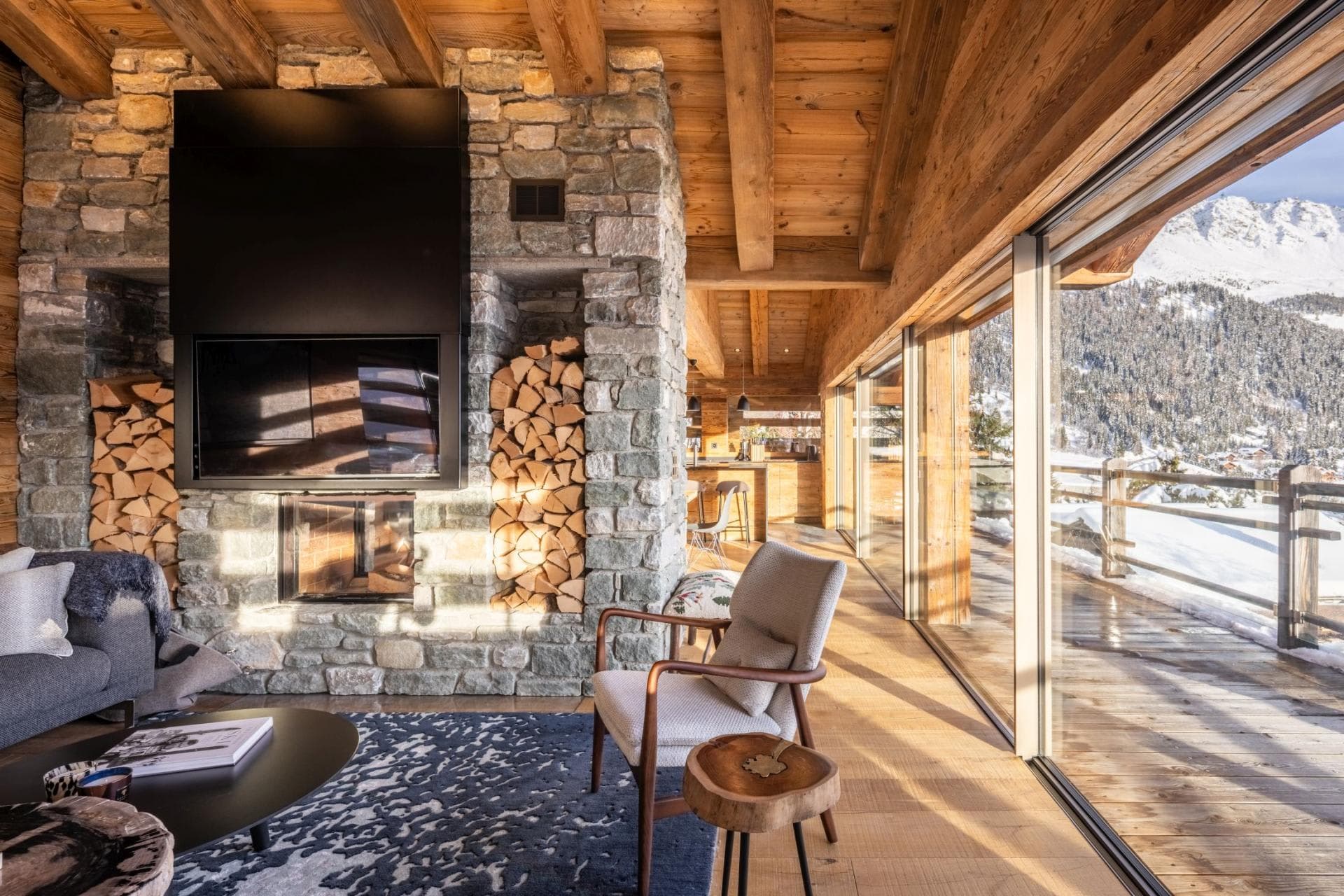 Living area with wood-burning fireplace and floor-to-ceiling mountain views