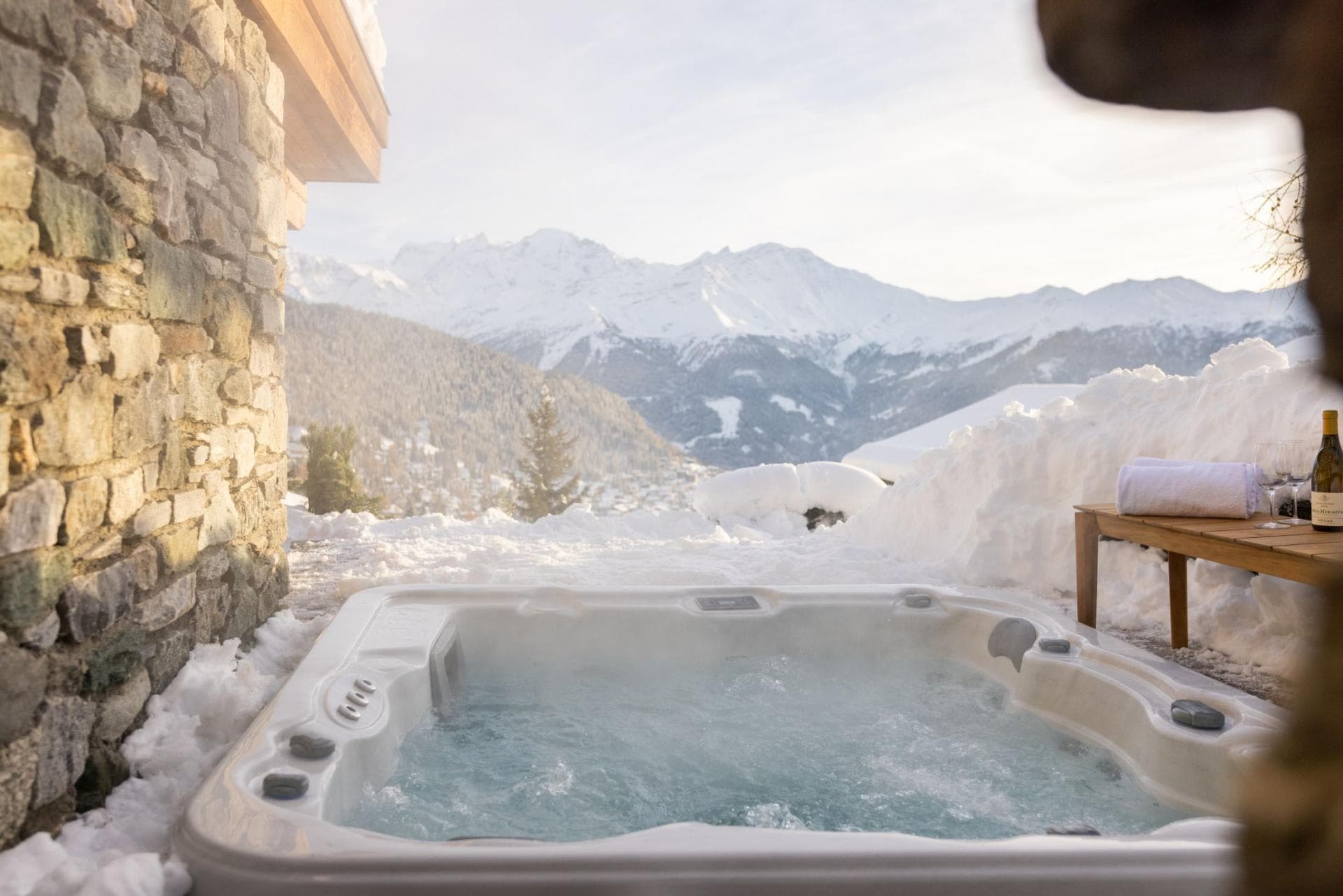 Outdoor hot tub with panoramic mountain views and side table