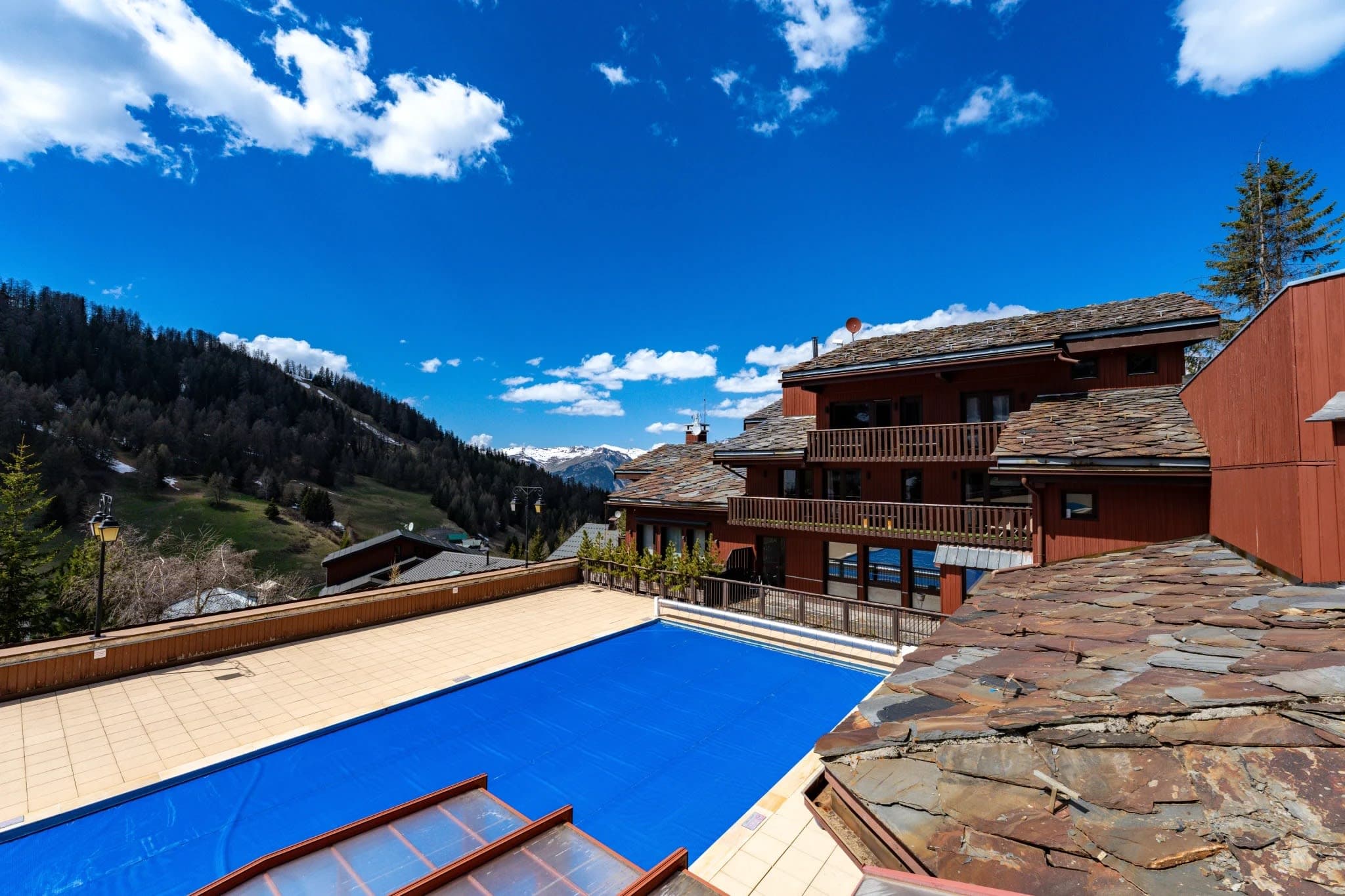 Shared swimming pool with retractable cover and mountain views