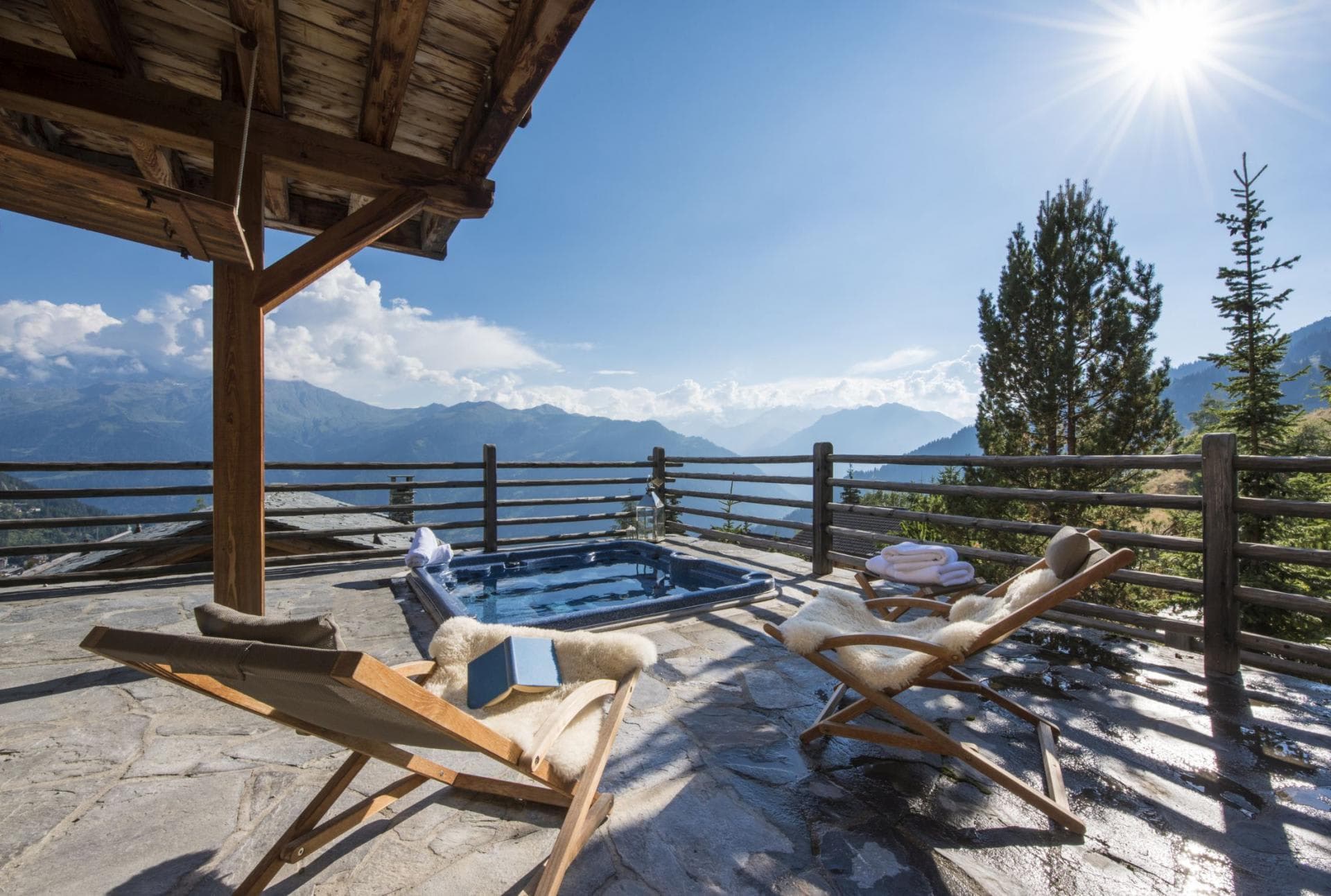 Stone sun terrace with sunken hot tub and panoramic mountain views