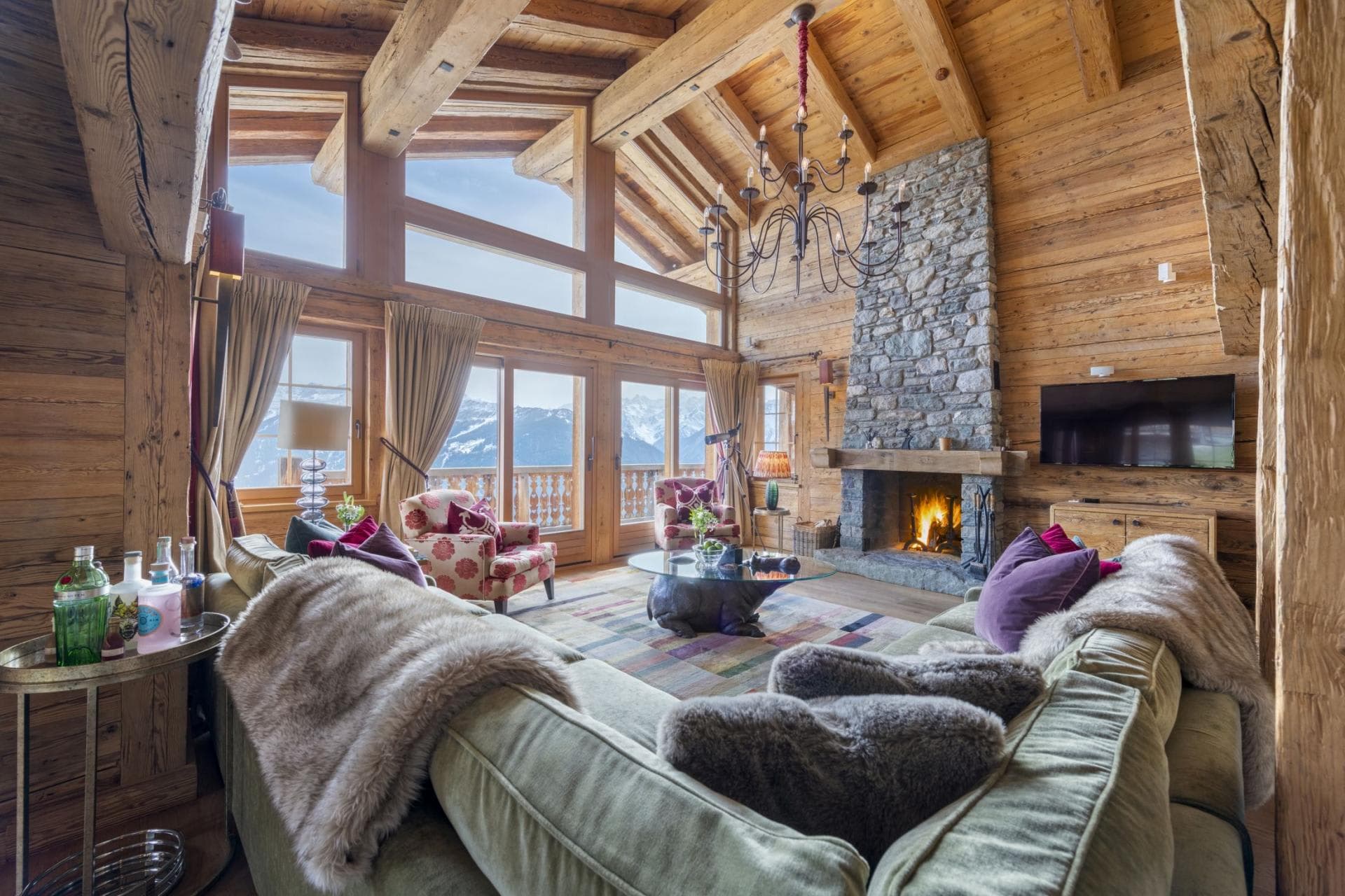 Living area with wood-burning fireplace and floor-to-ceiling mountain views