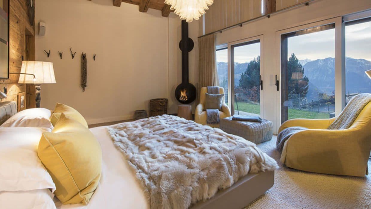 Primary bedroom with wood-burning stove and mountain valley views