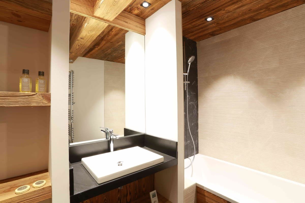 Bathroom with vessel sink and bathtub with handheld shower head