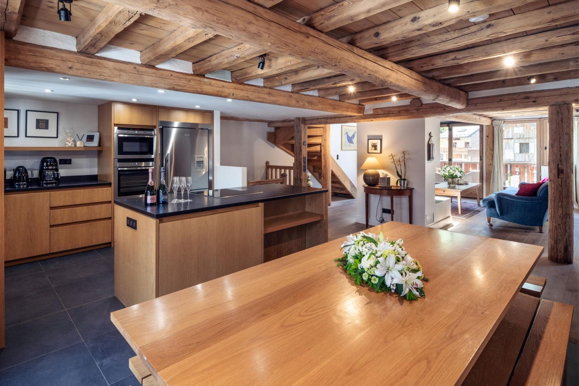 Open-plan kitchen and dining area with original timber beams and induction cooktop