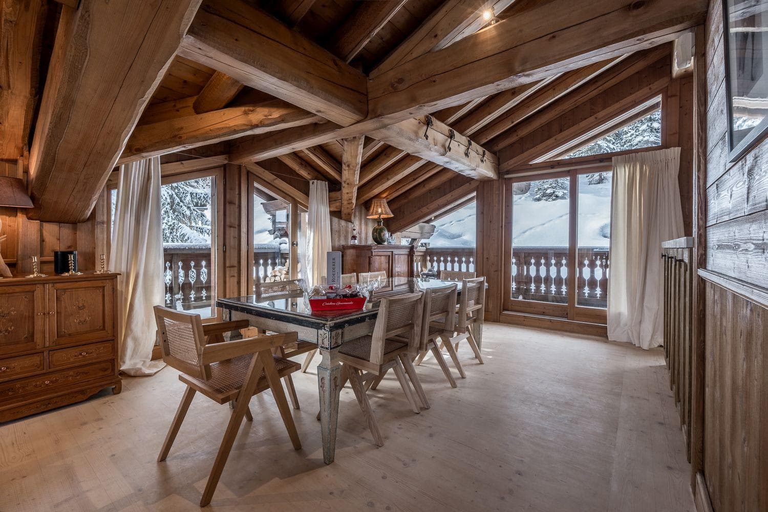 Dining area with seating for 8 and balcony access to snowy views