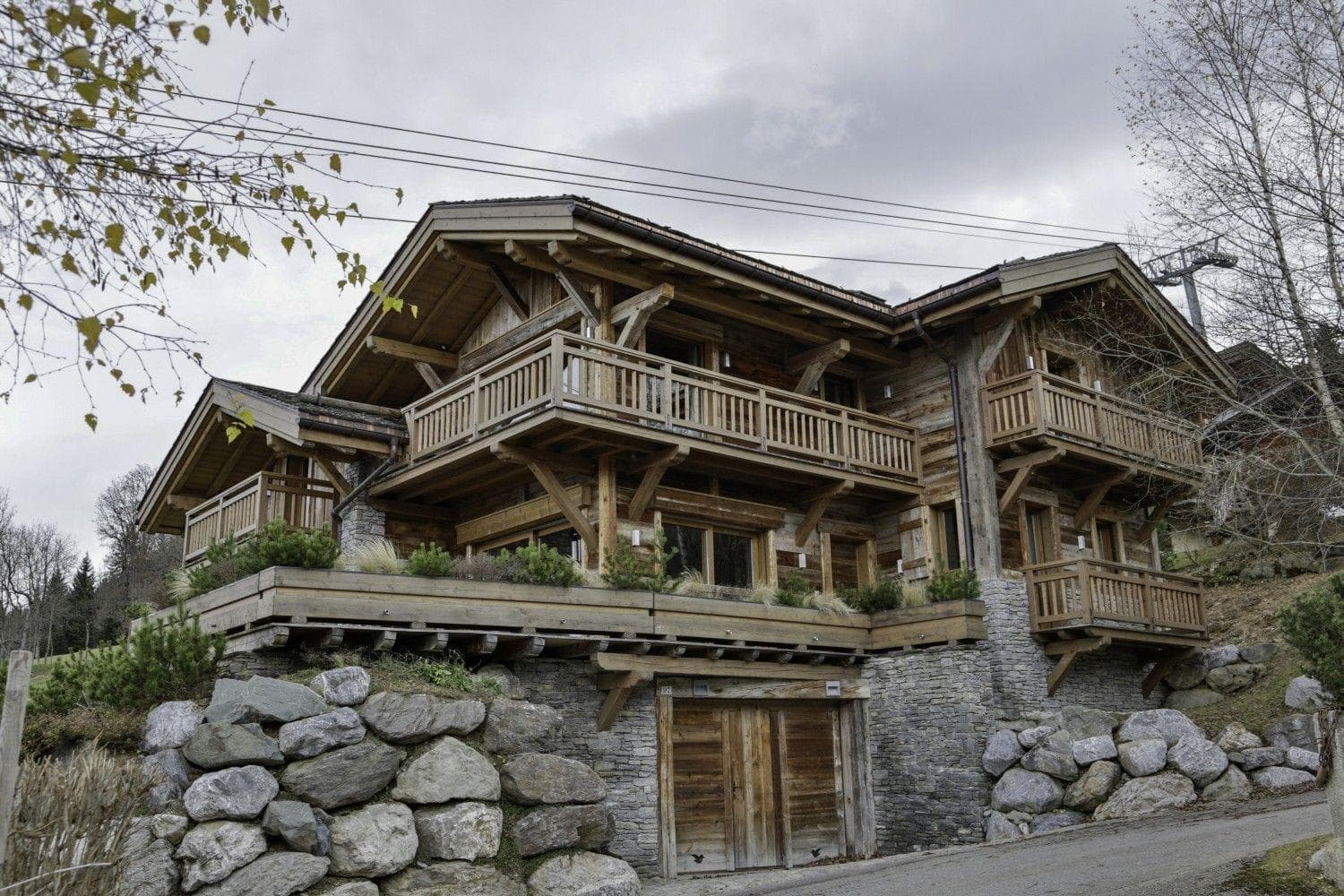 Timber chalet exterior with private garage and multiple wraparound balconies