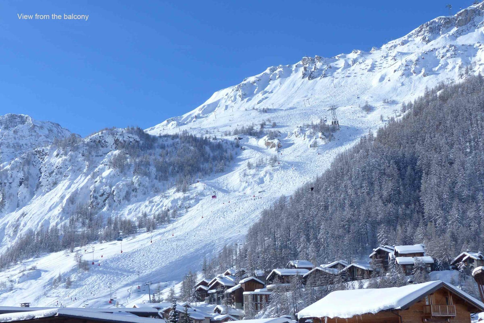 Balcony view of ski slopes and mountain cable car