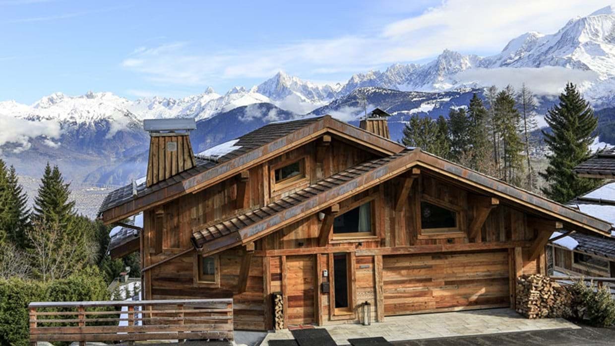 Timber chalet exterior with private garage and alpine mountain views