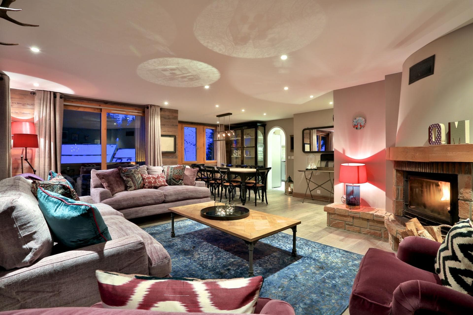 Open-plan living area with wood-burning fireplace and dining seating for 8