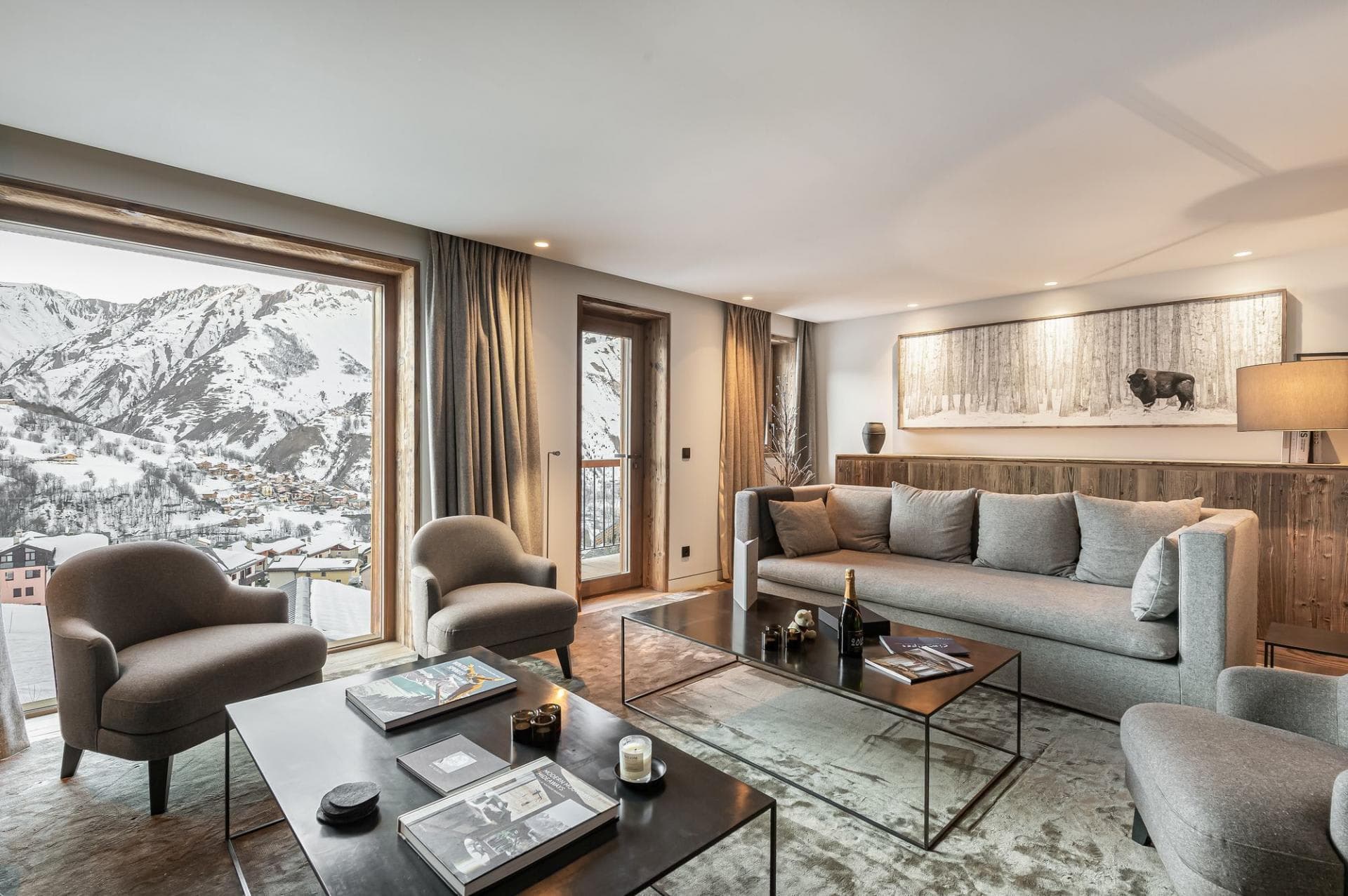 Living area with floor-to-ceiling mountain views and balcony access