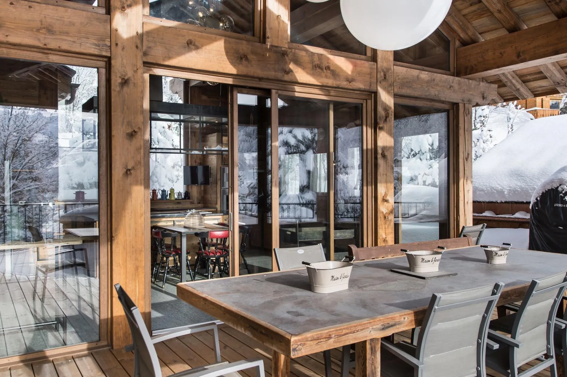 Covered terrace with a dining table and snowy mountain views