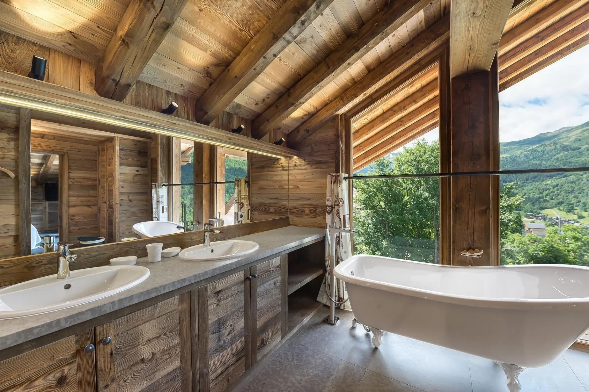 Bathroom with twin basins, a freestanding bath and mountain views