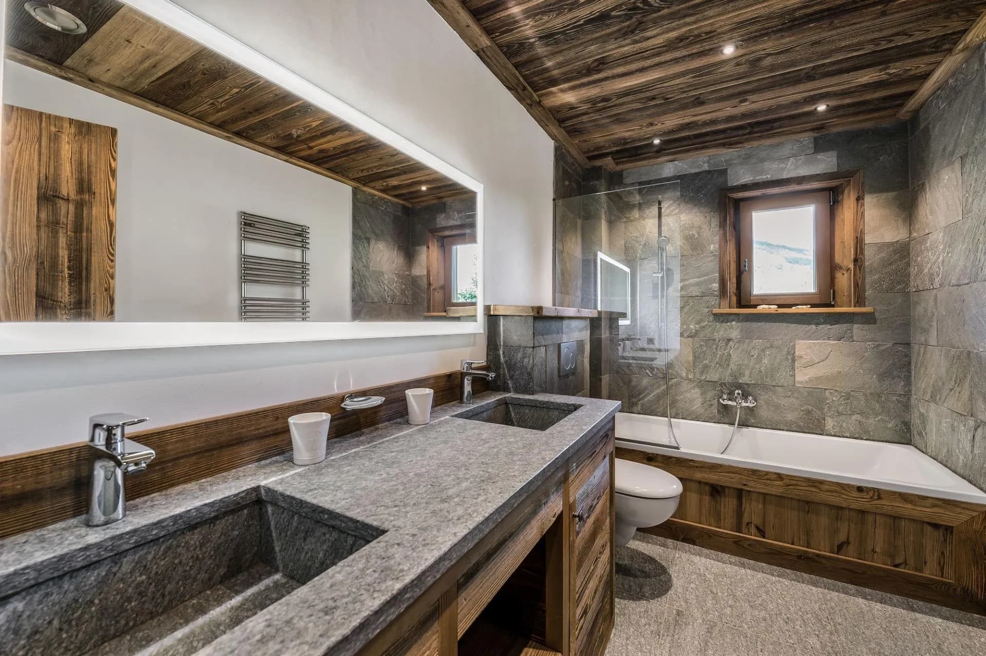 Bathroom with a stone vanity, bathtub and heated towel rail
