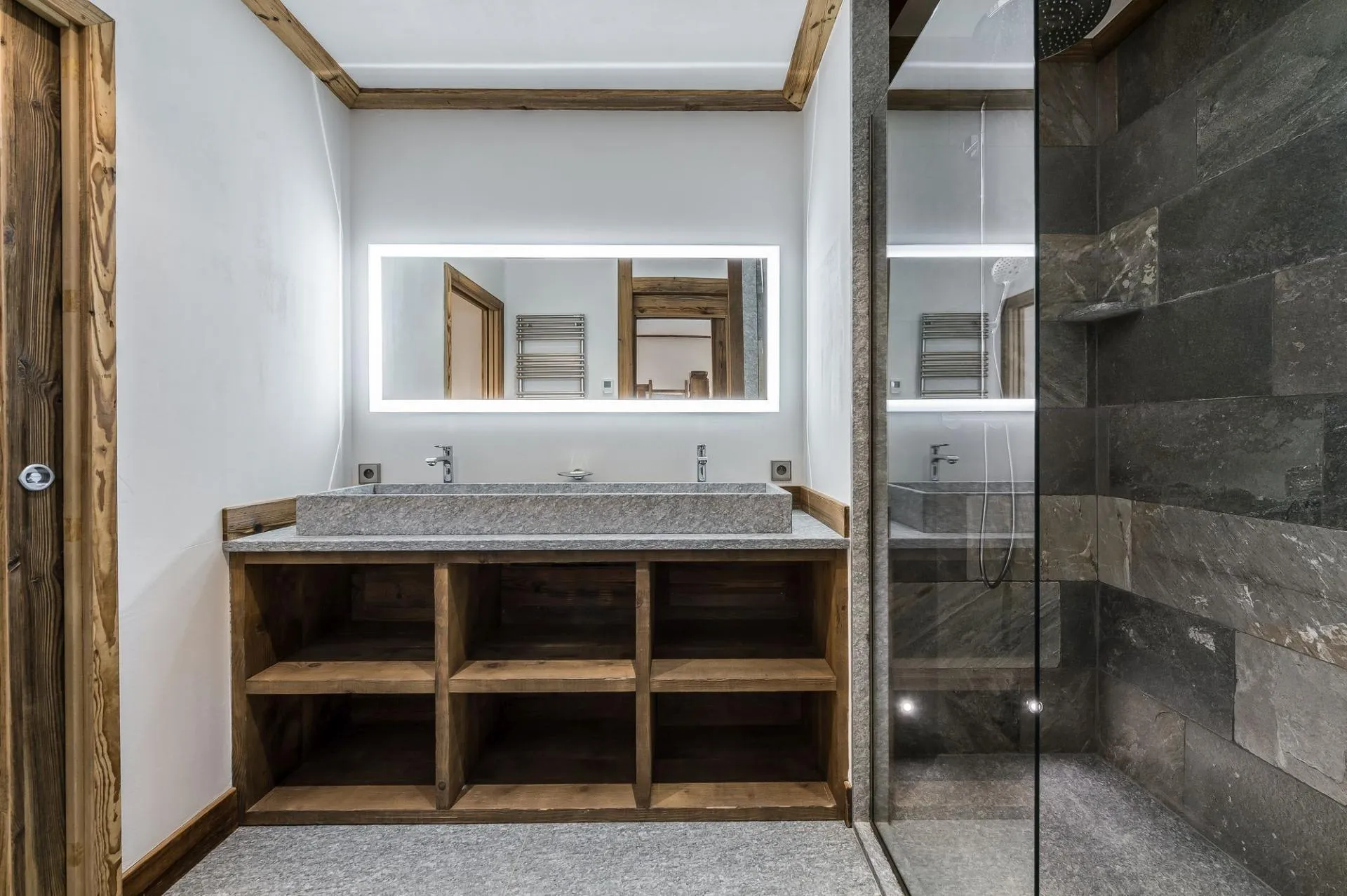 Stone trough basin beside a walk-in stone shower