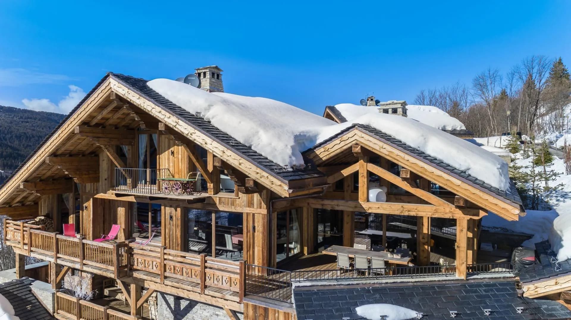 Timber chalet exterior with balconies and an outdoor dining area