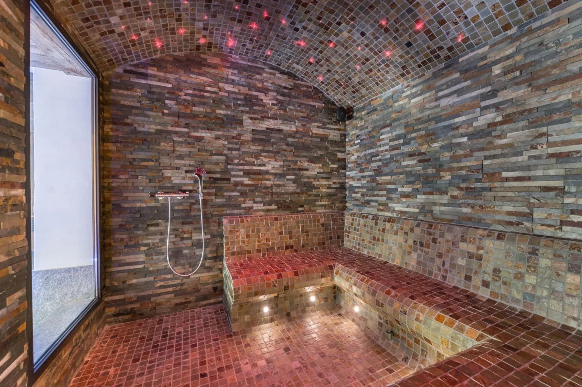 Stone hammam with bench seating and a fibre-optic ceiling